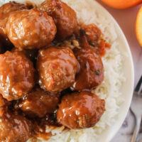 zoomed in plate of rice with meatballs on top. Photo taken from the top looking down.