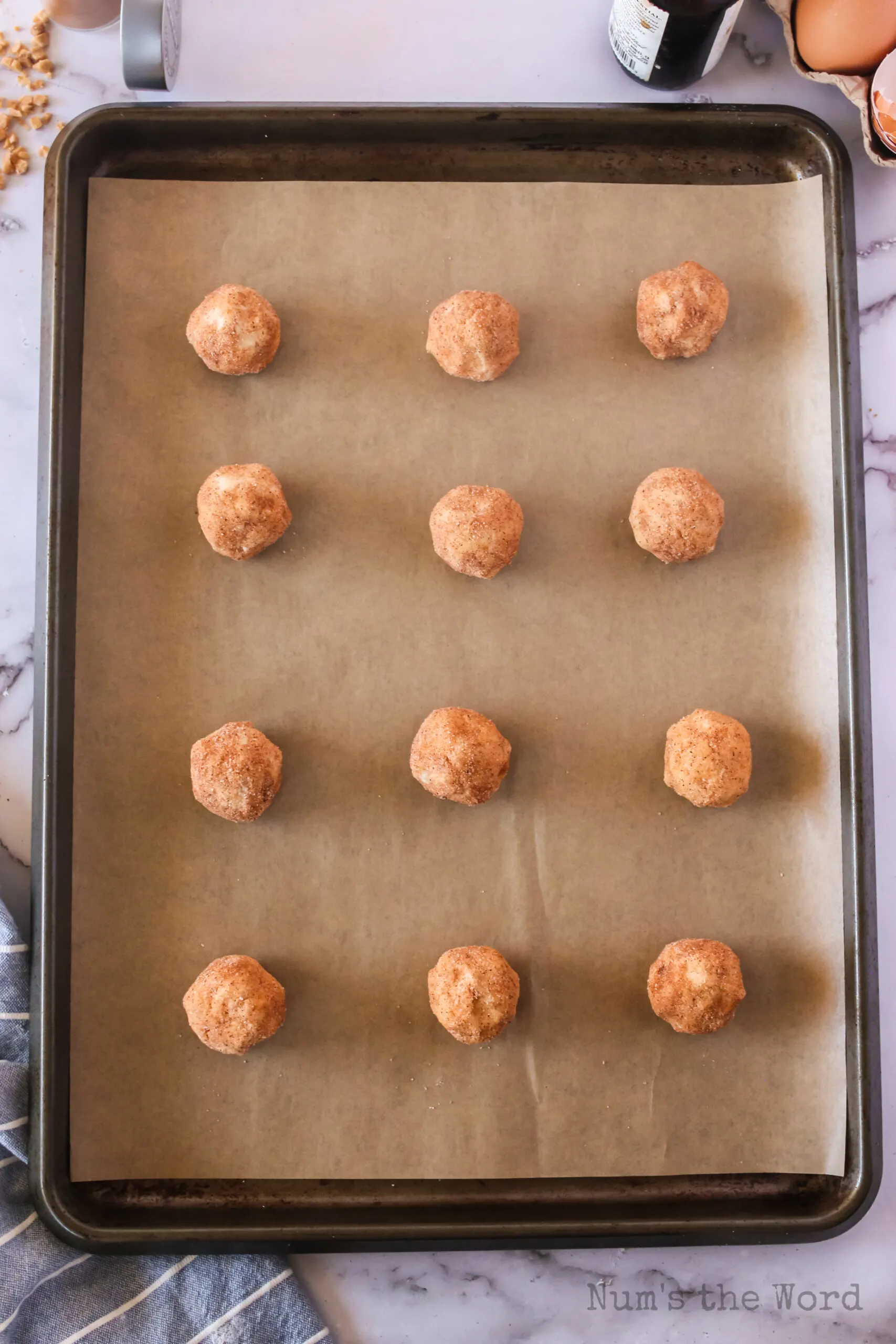 12 cookie balls on lined cookie sheet unbaked