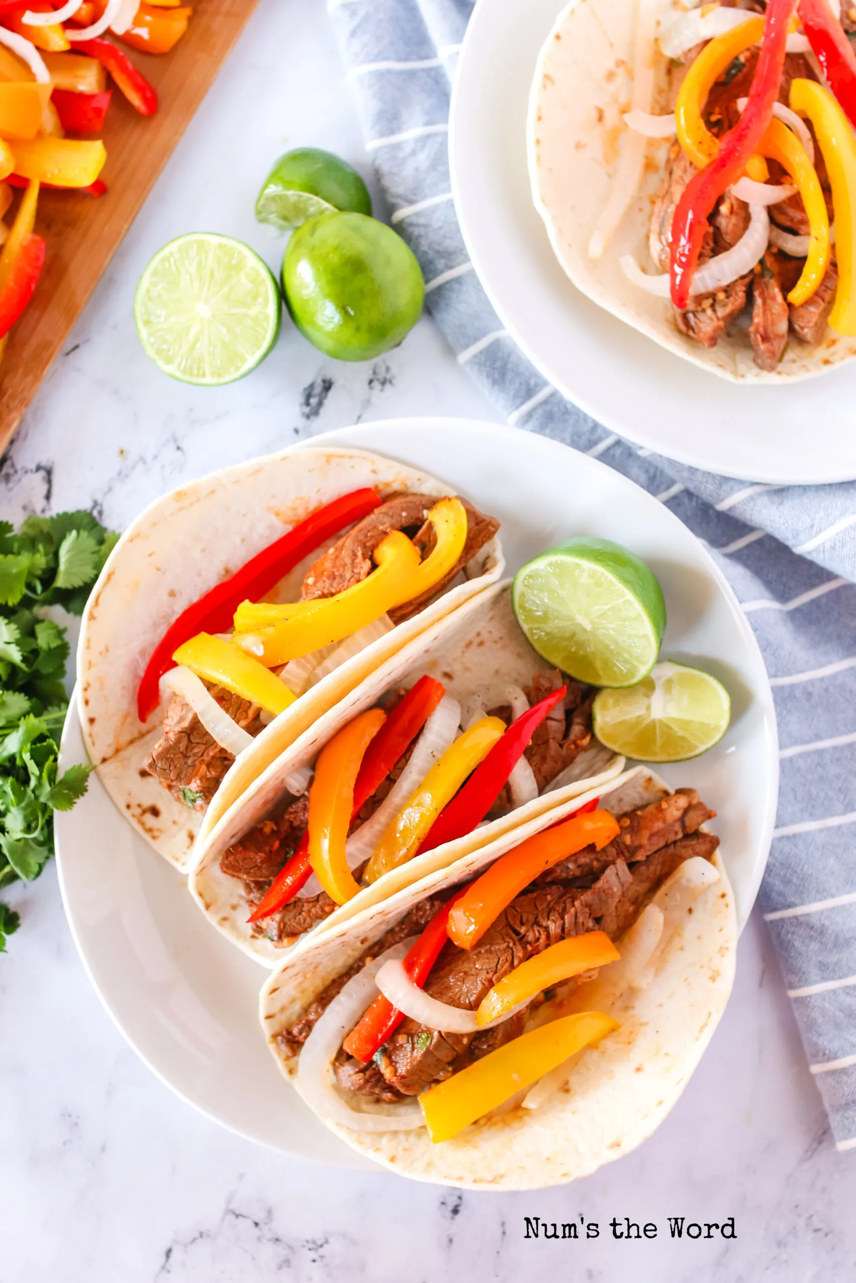 top view of 3 fajitas on plate with lime.