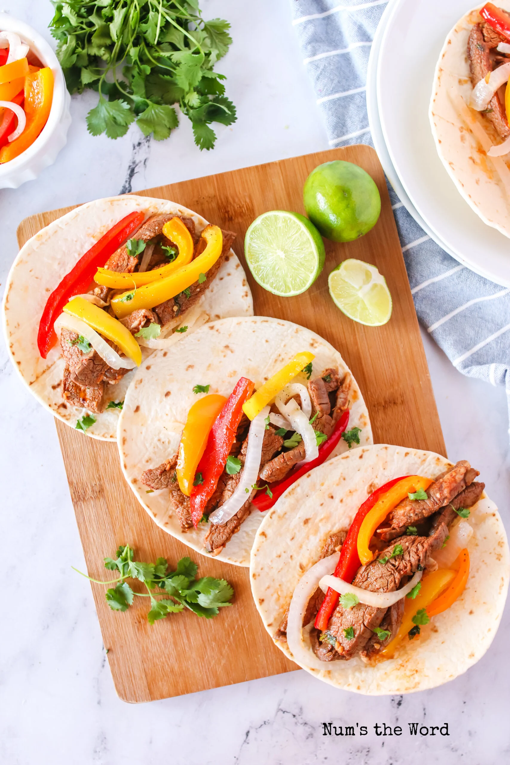 3 open fajitas on a wooden board