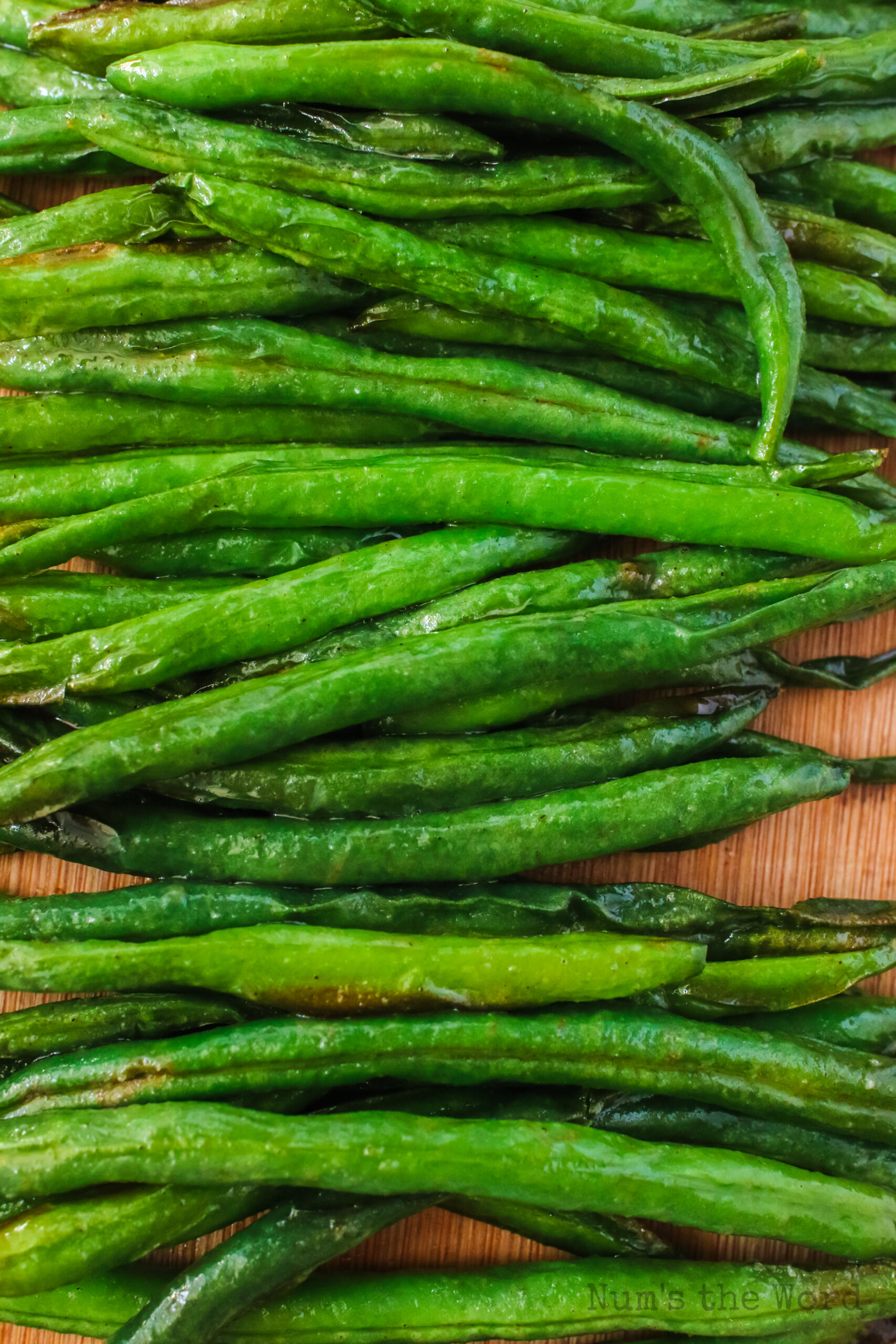 zoomed in image of cooked green beans on a serving board