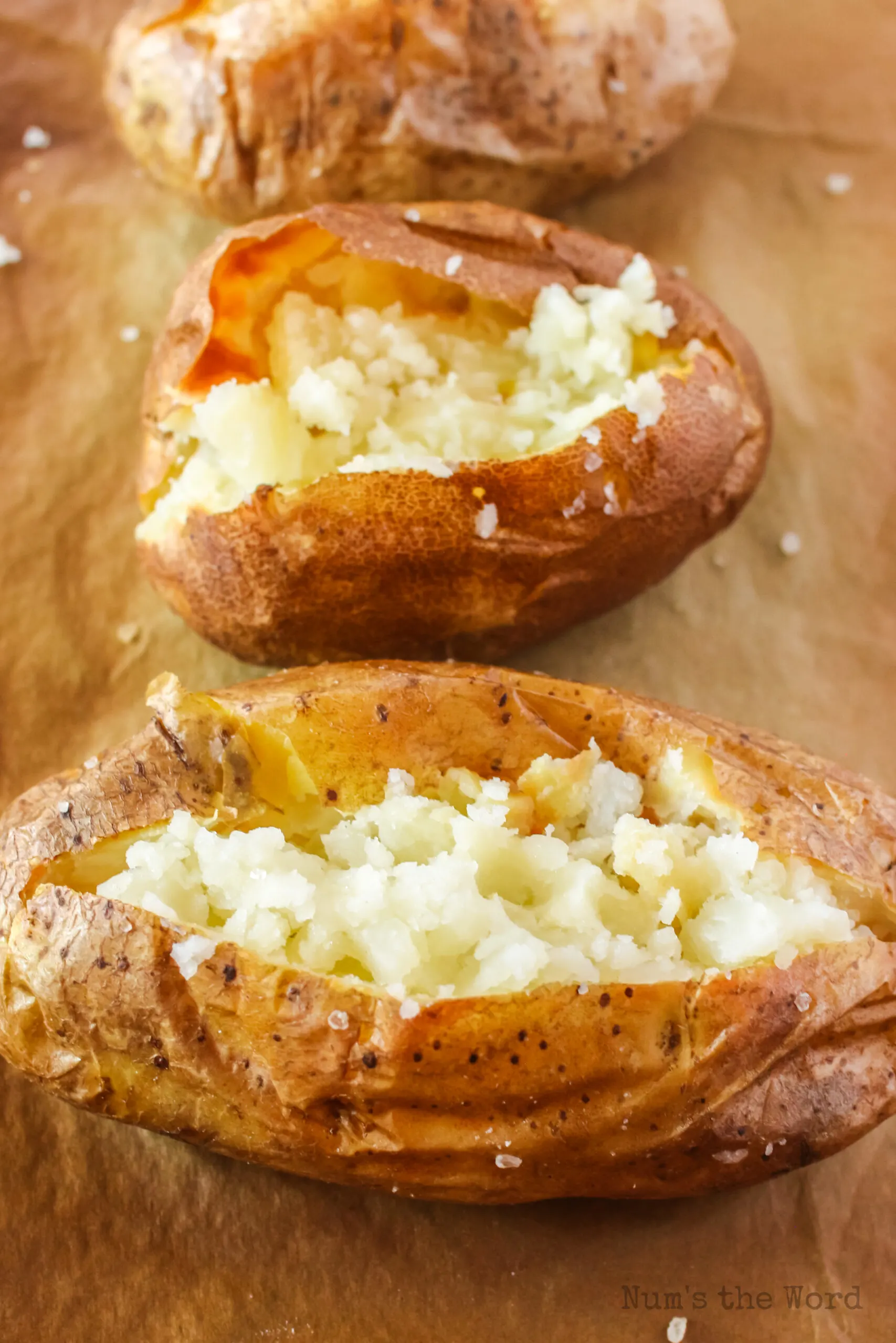 side view of baked potatoes on baking sheet