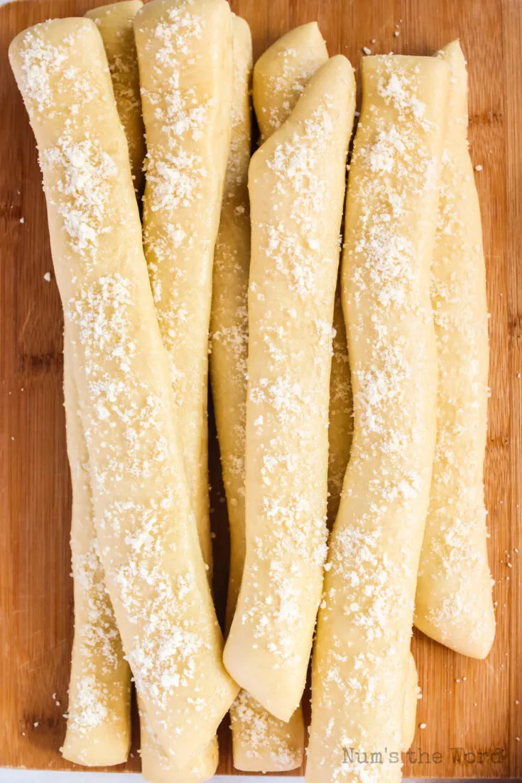 fresh baked bread sticks on wooden serving board