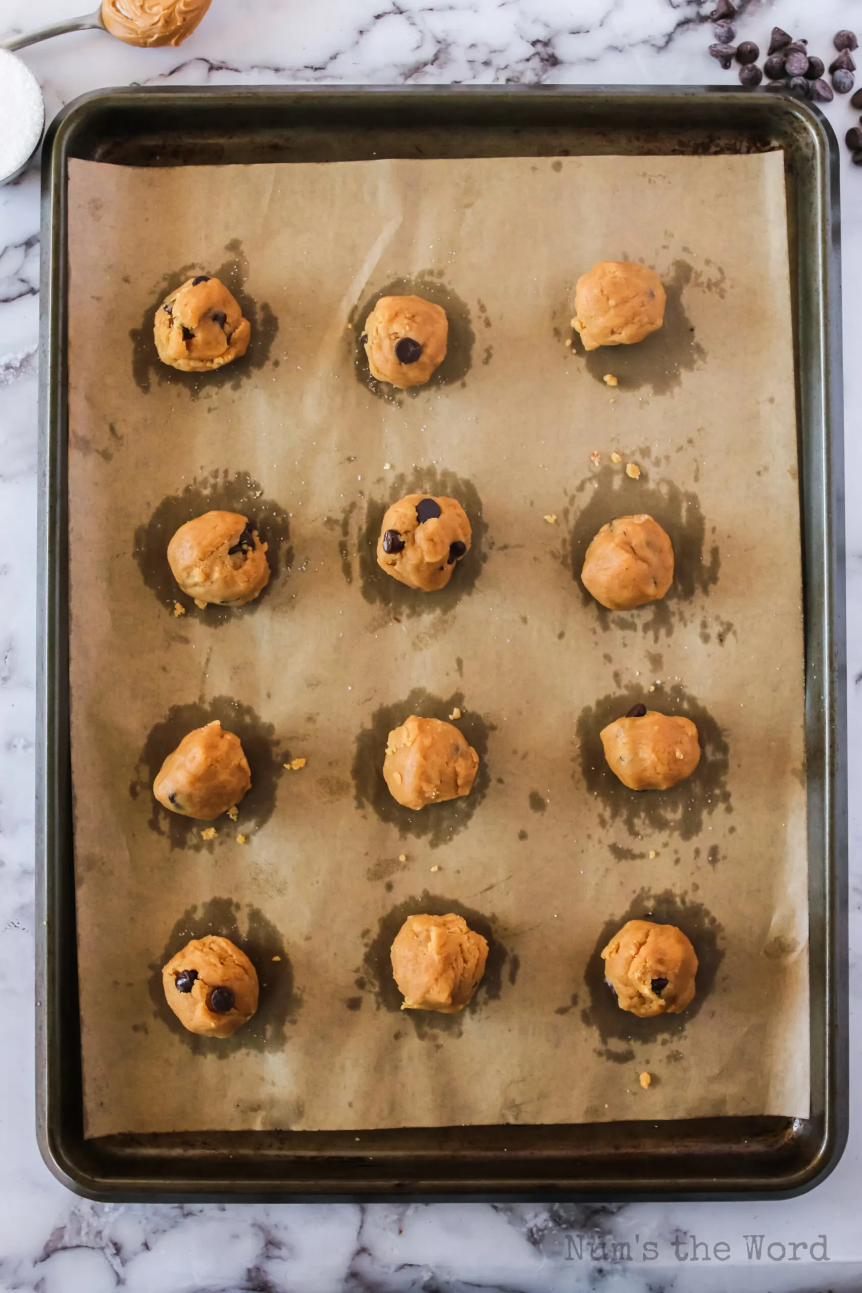 chocolate chip peanut butter cookie dough in balls on cookie sheet