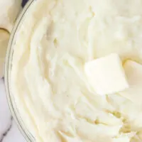 zoomed in image of mashed potatoes with a pat of butter on top