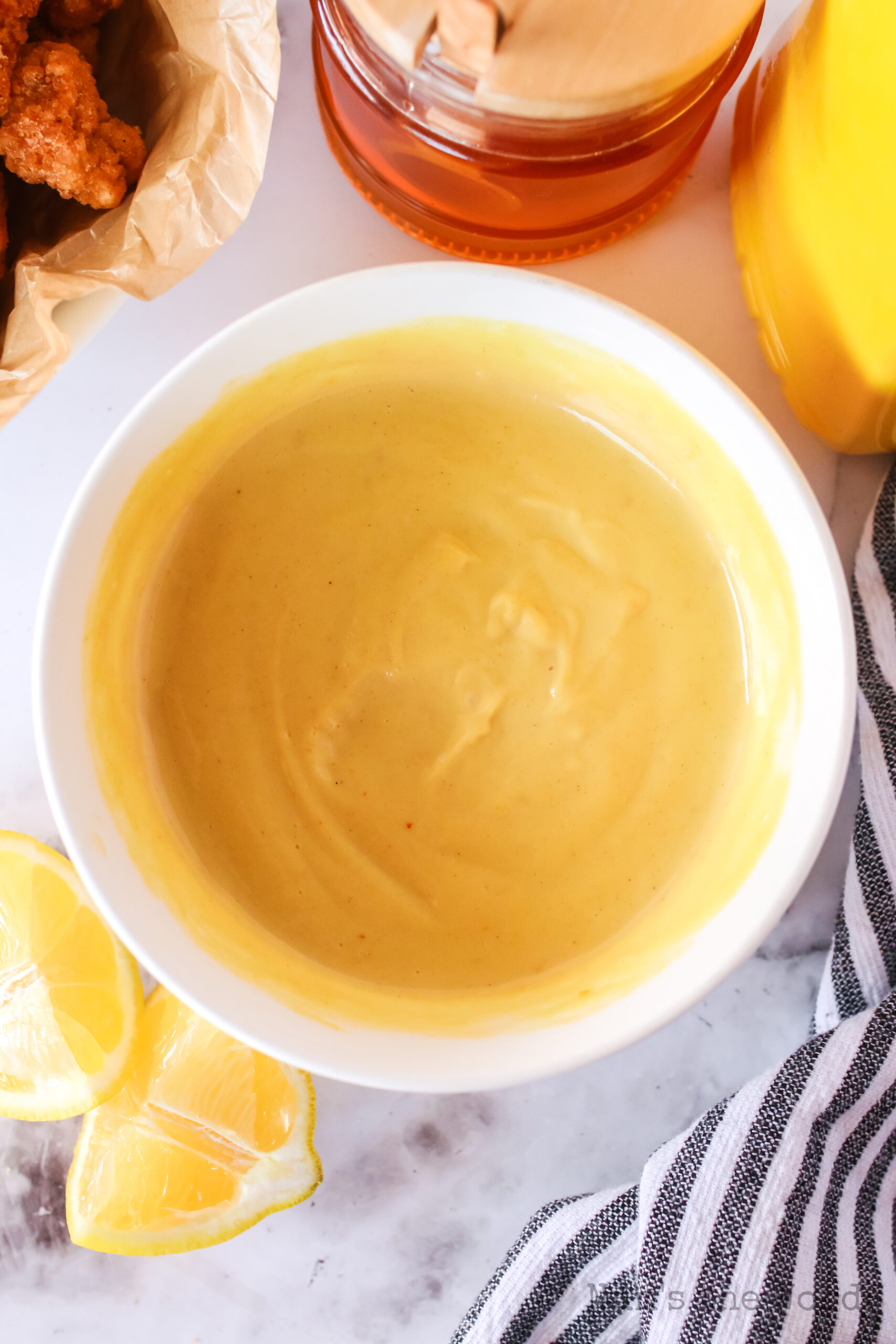 zoomed out image of honey mustard dressing in a bowl