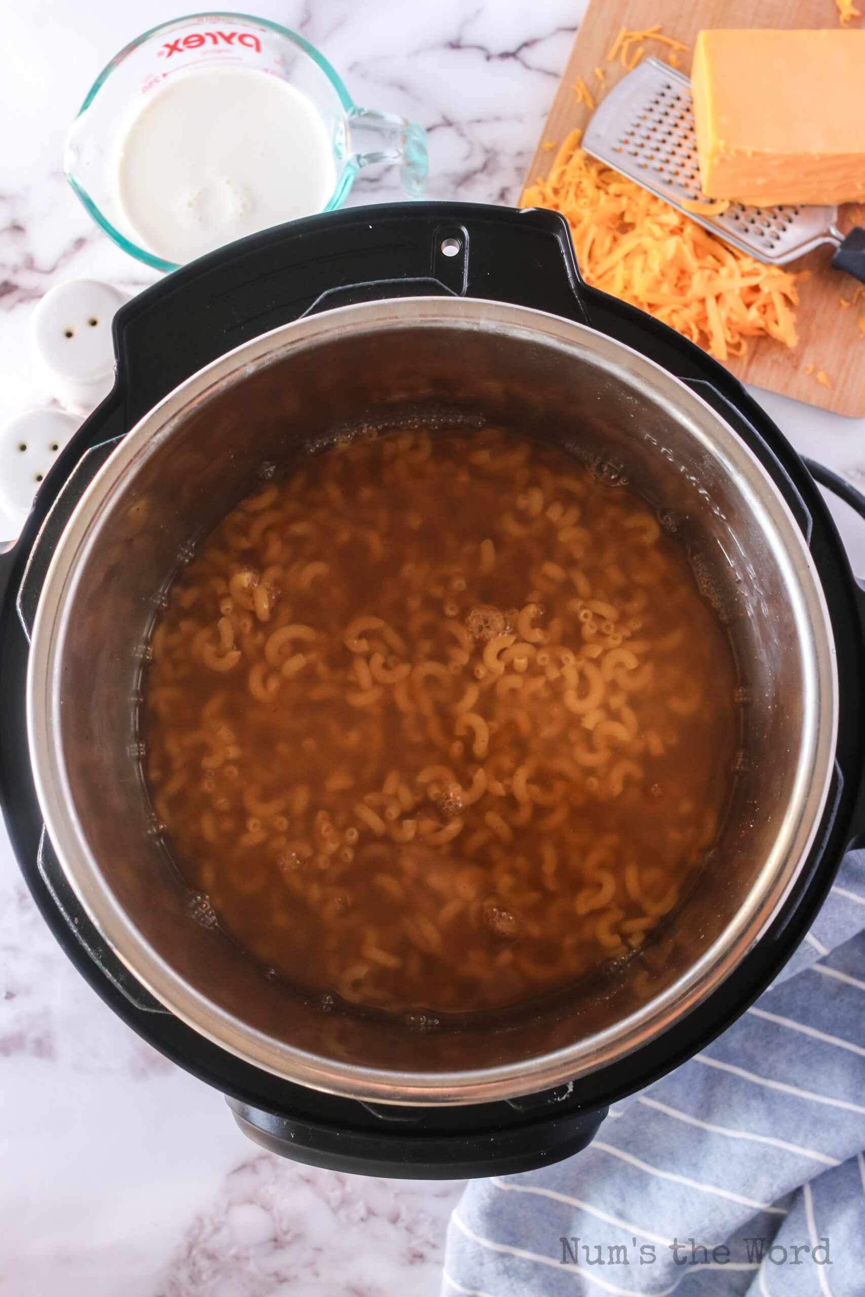 chicken broth, water, salt, mustard powder, paprika, black pepper, garlic powder, and macaroni noodles added to instant pot.