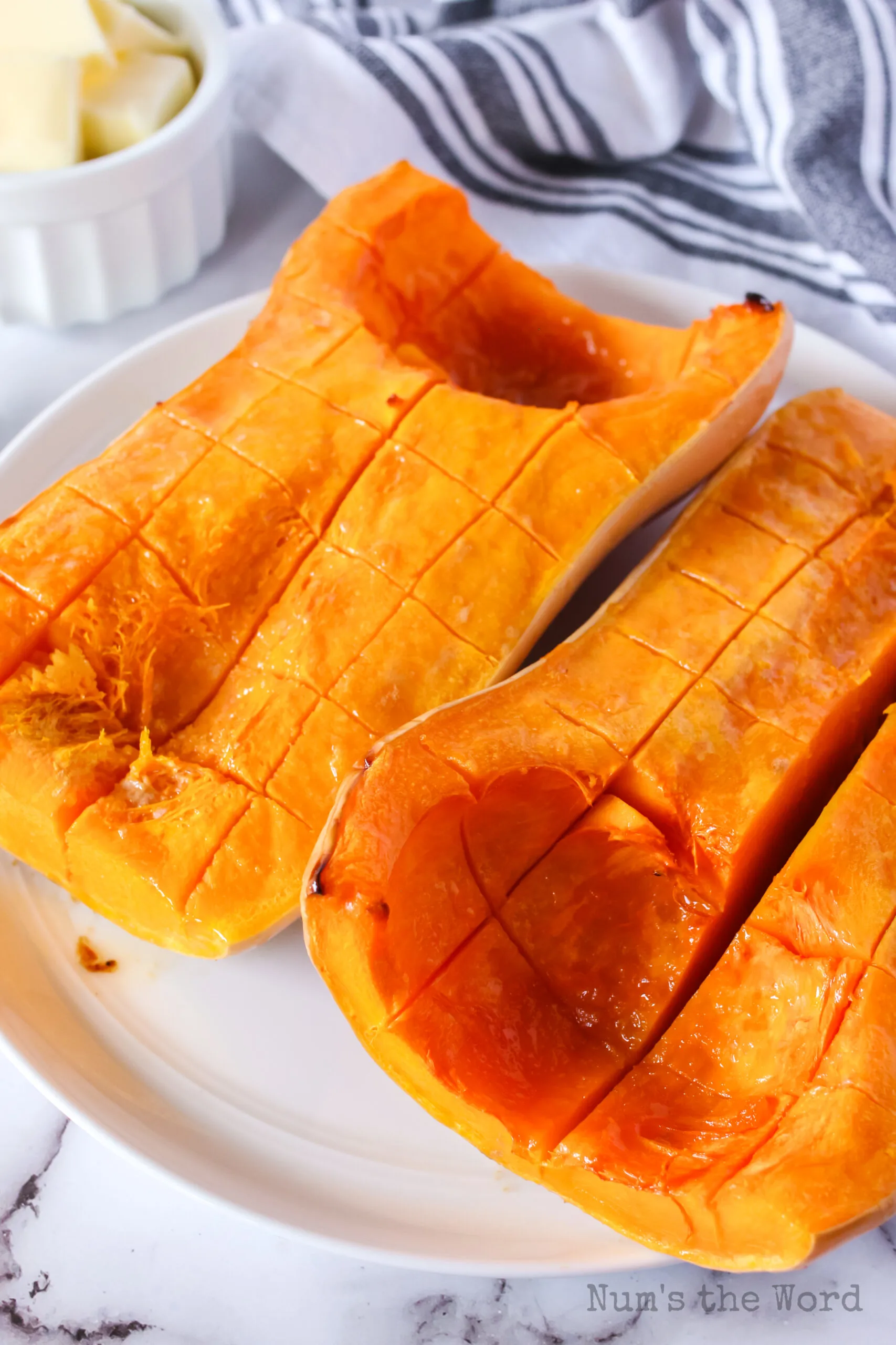 zoomed out photo of two squash halves on plate cut into pieces