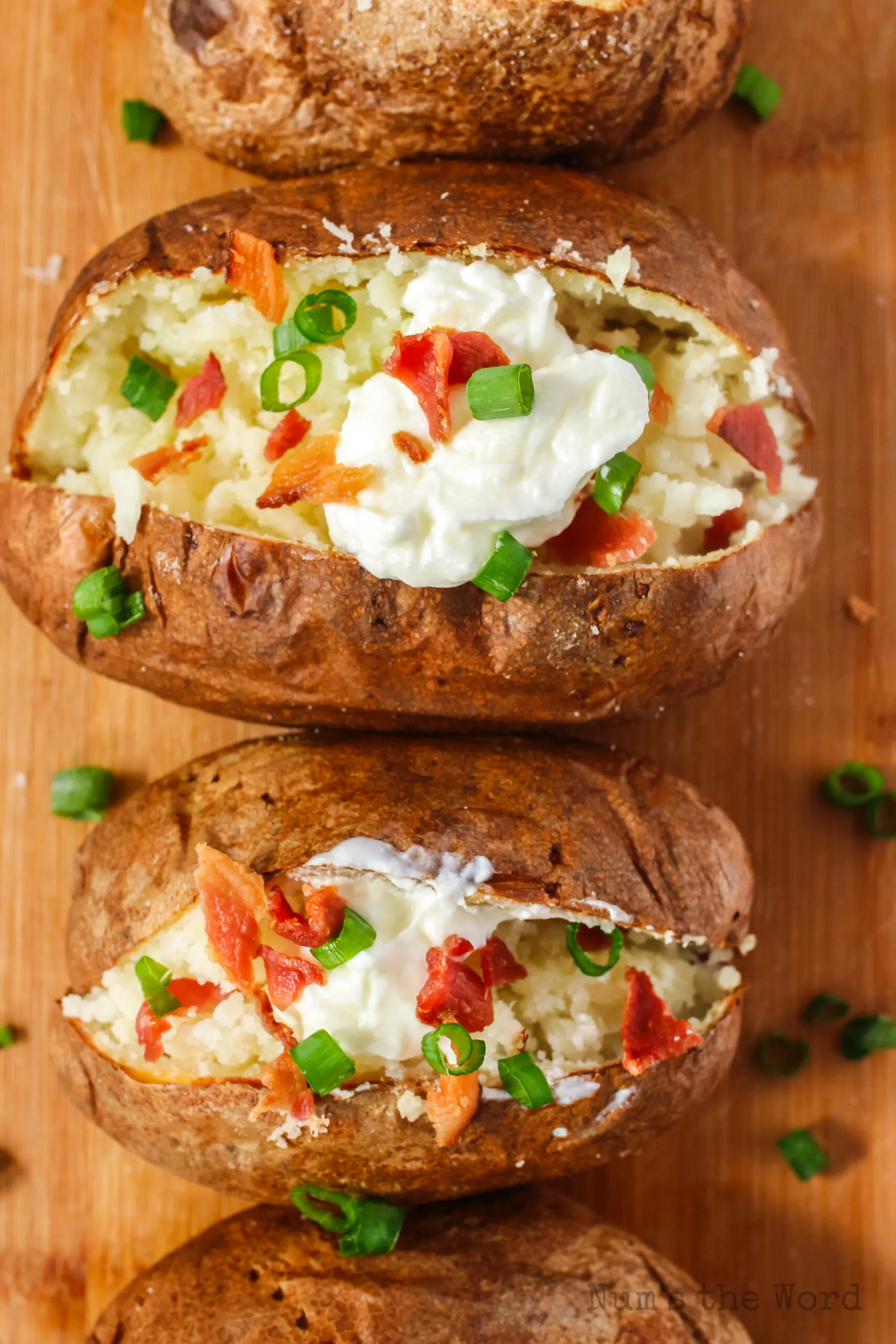 zoomed in image of loaded potatoes full of sour cream, chives, and bacon