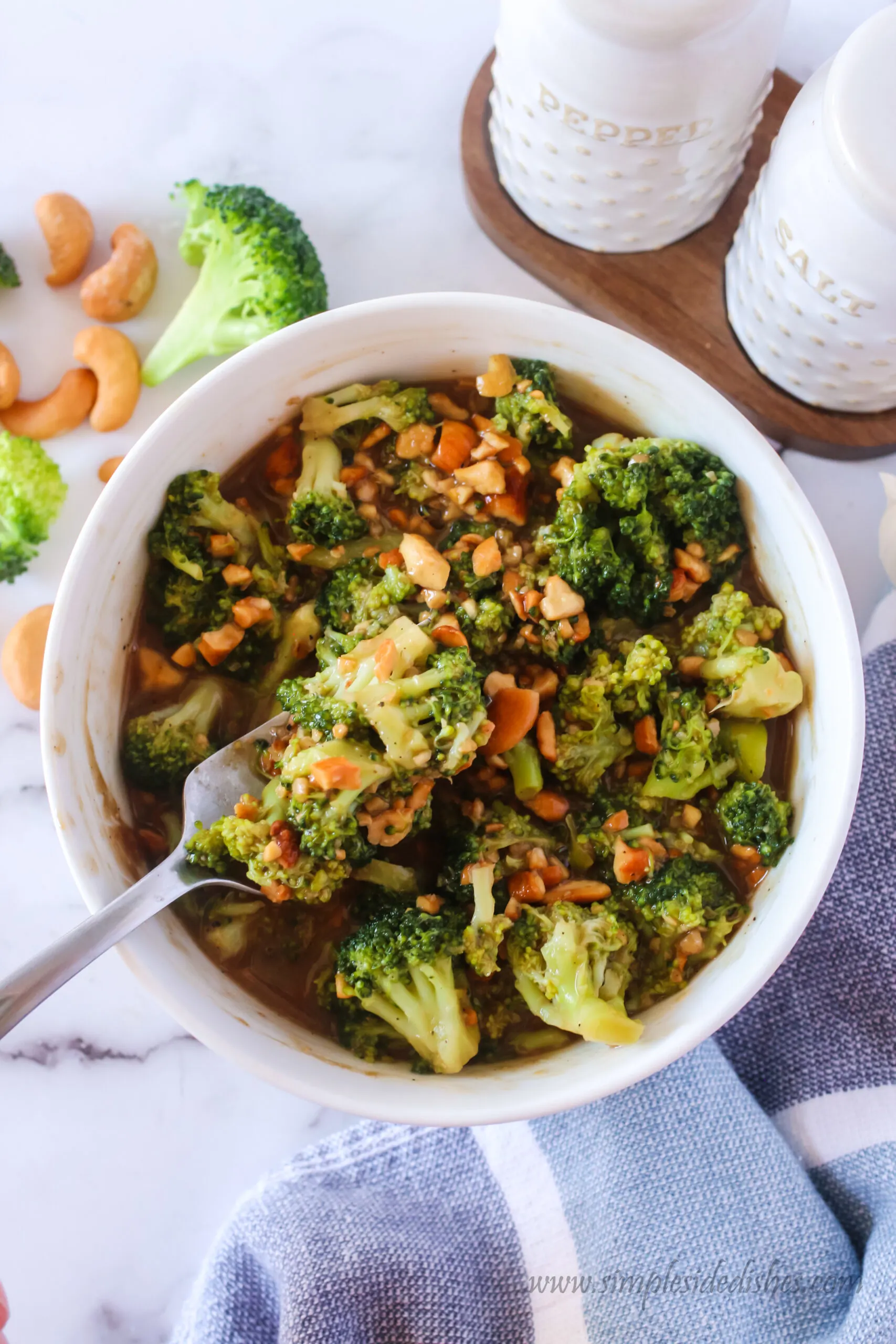 bowl of cashew broccoli with a fork full being removed