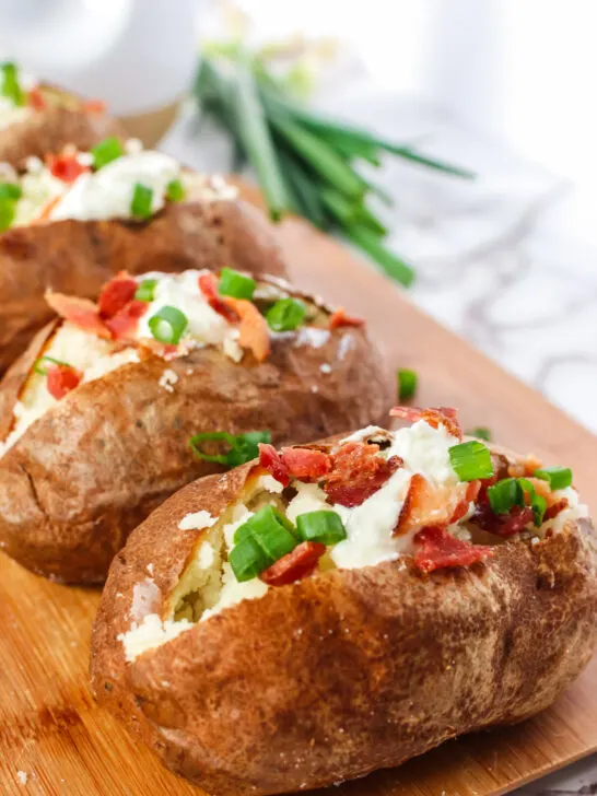 Side view of split potatoes on cutting board fully loaded
