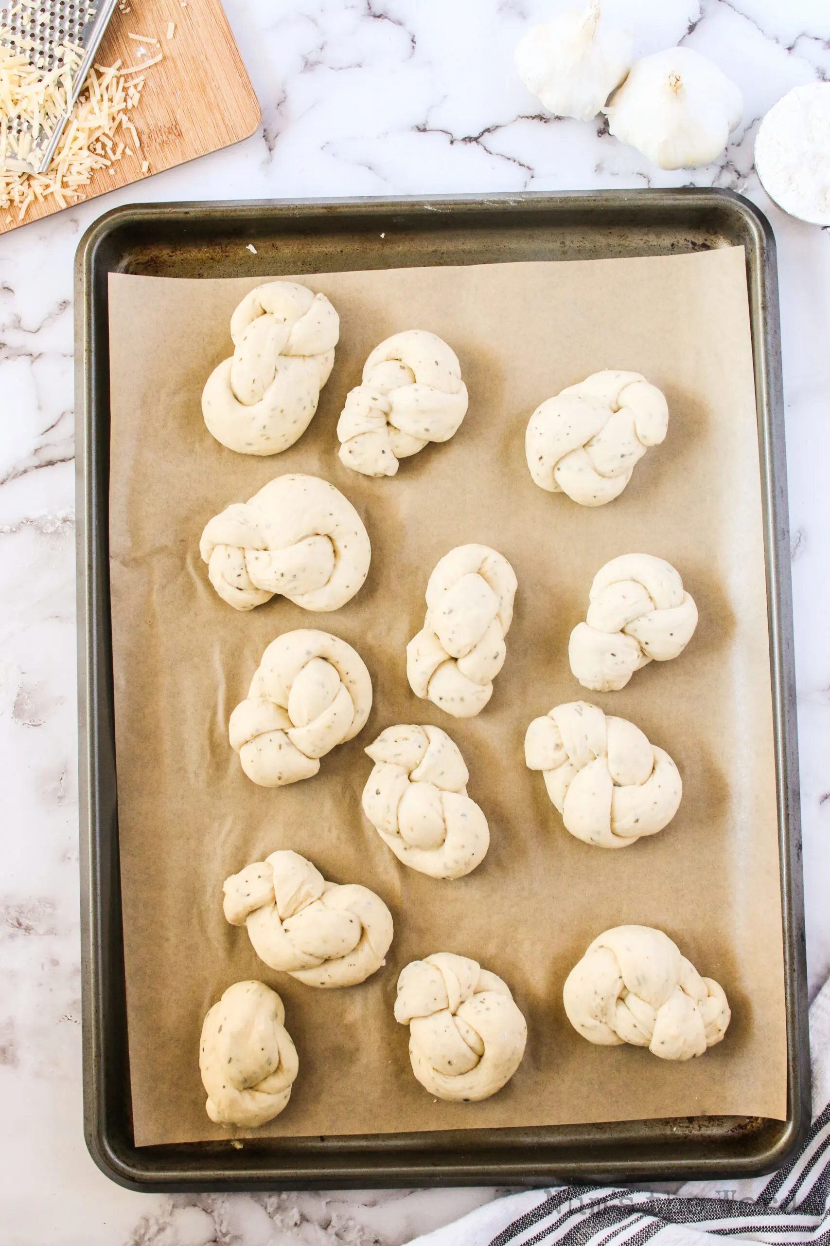 cookie sheet full of bread knots ready to bake