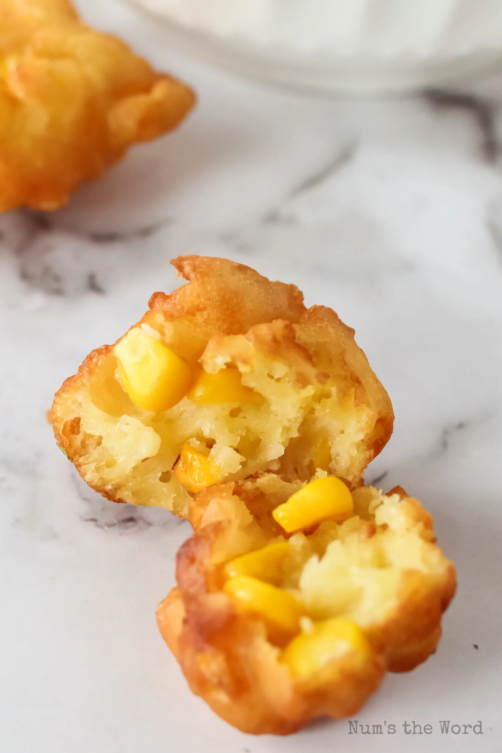 corn fritter on counter broken in half to show yummy insides