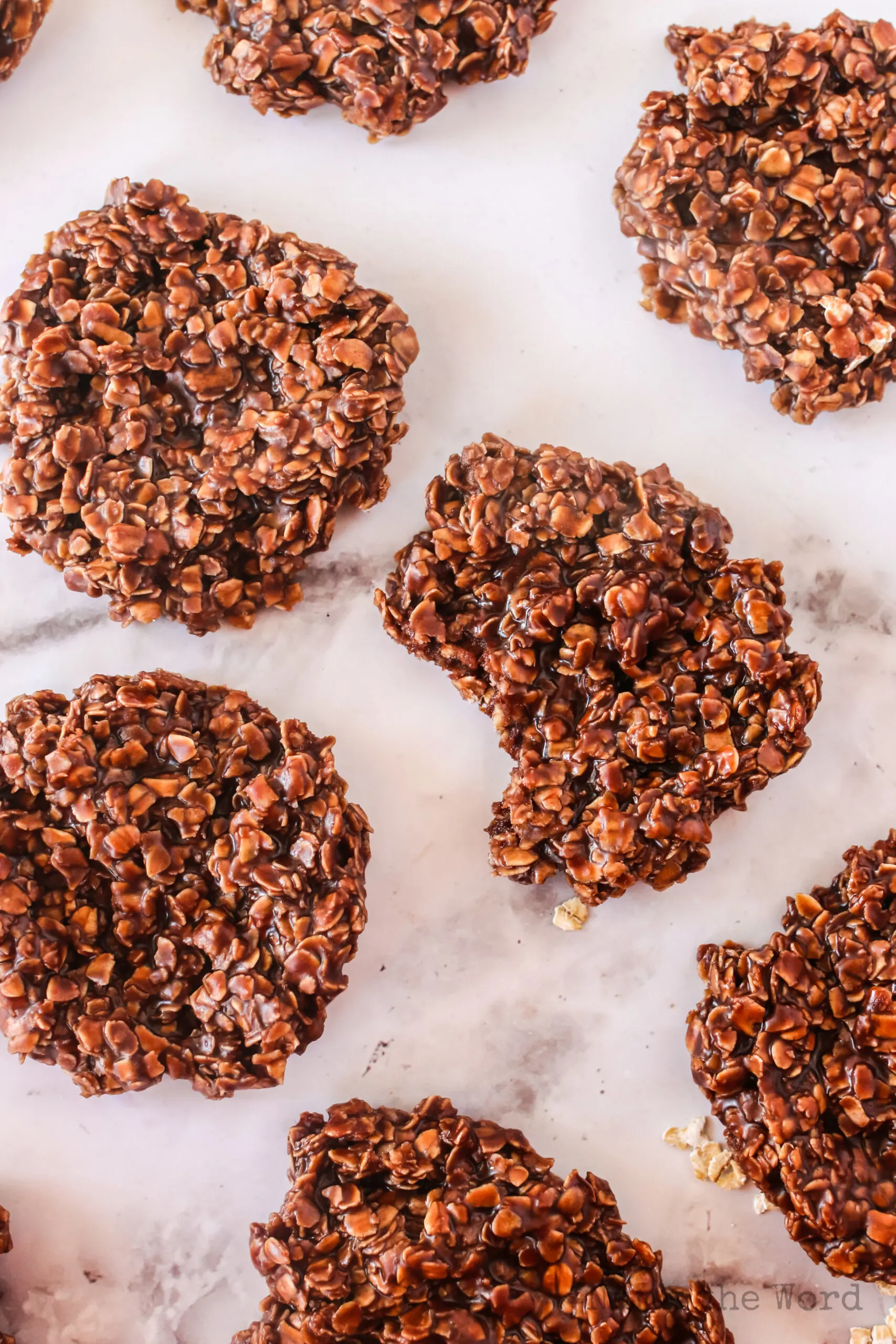 cookies laid out on counter with middle cooking missing a bite