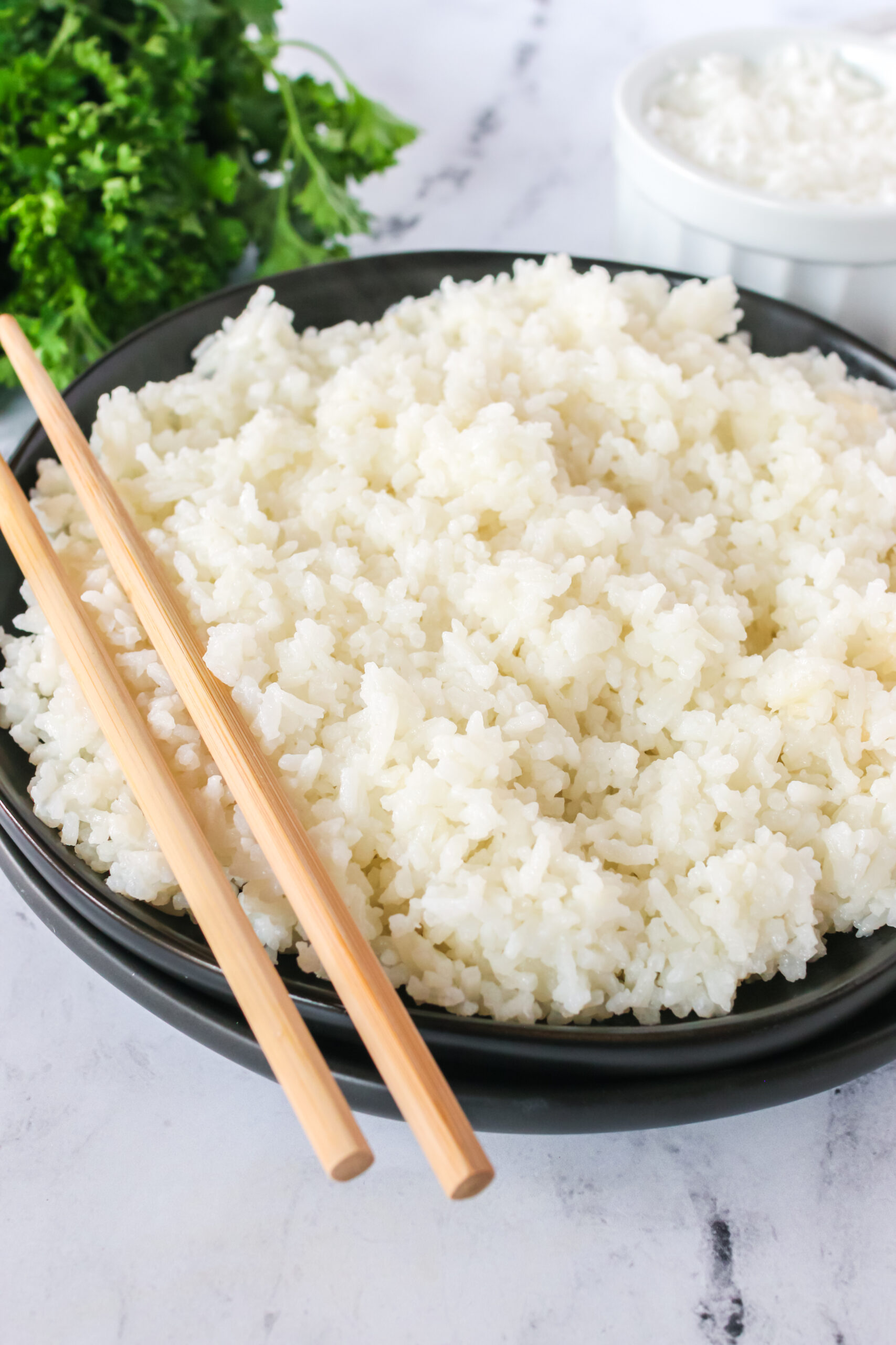 side view of bowl full of fluffy rice with chop sticks