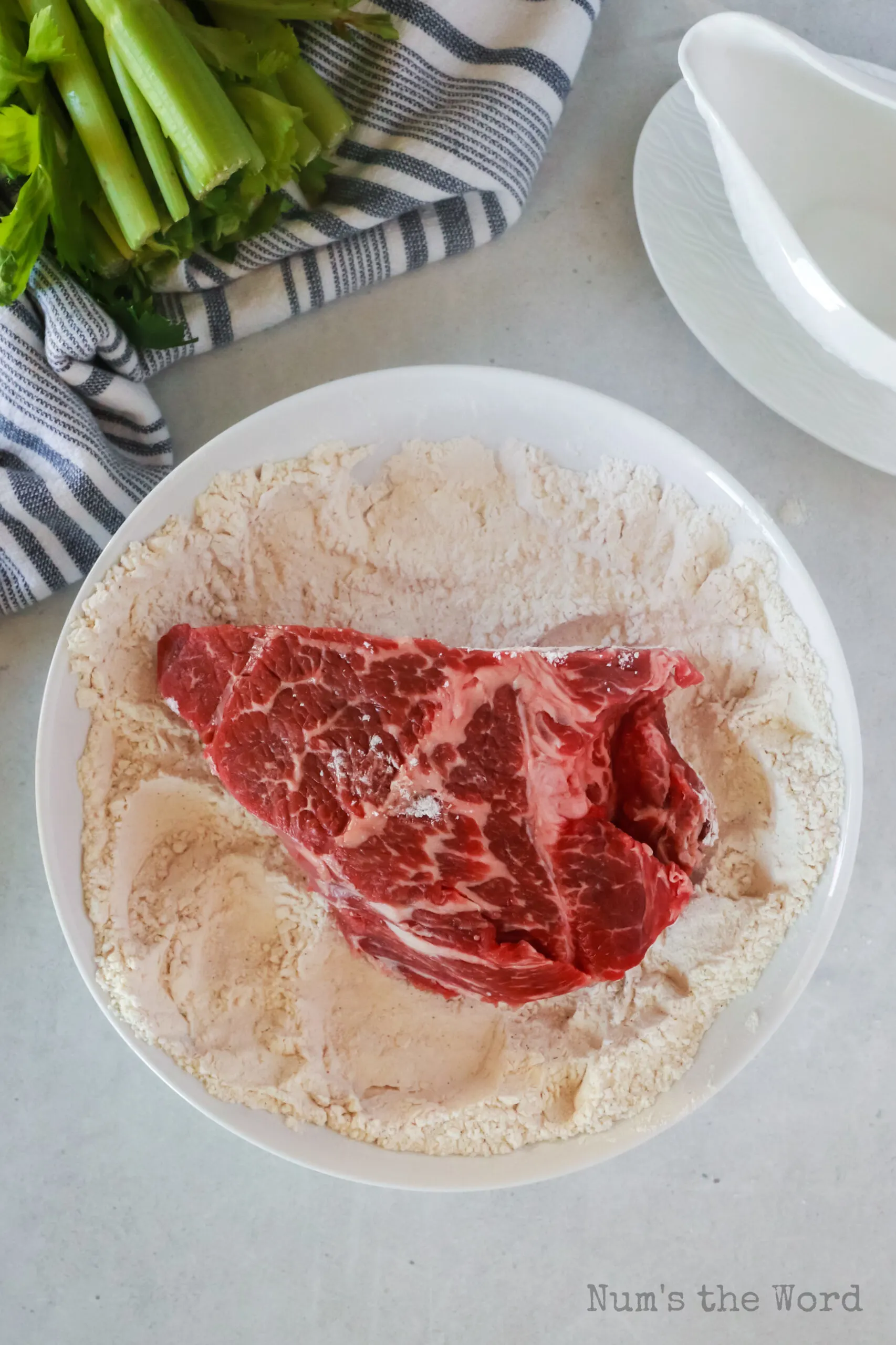 pot roast being dredged in flour mixture