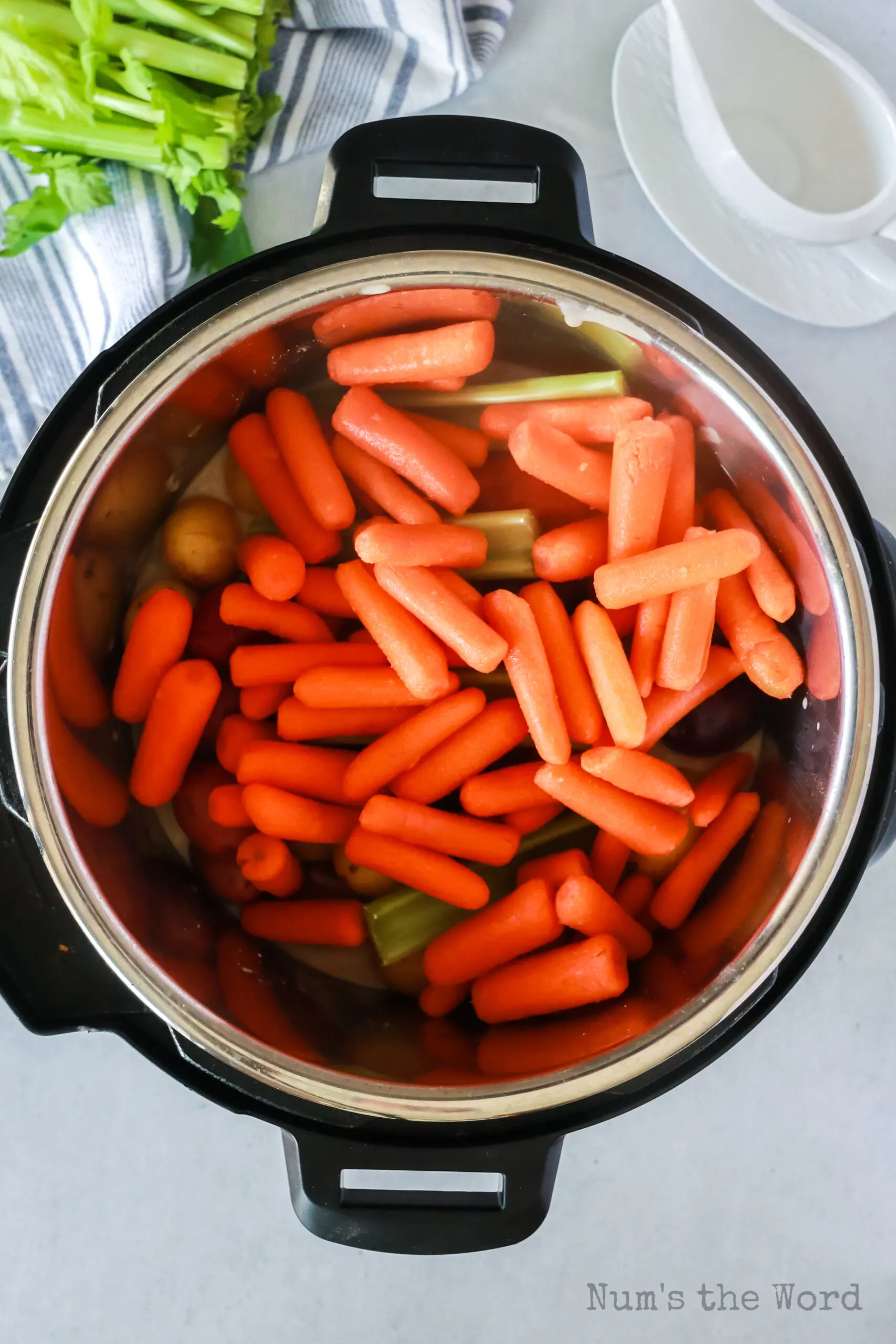 carrots, baby potatoes and celery placed on top of gravy