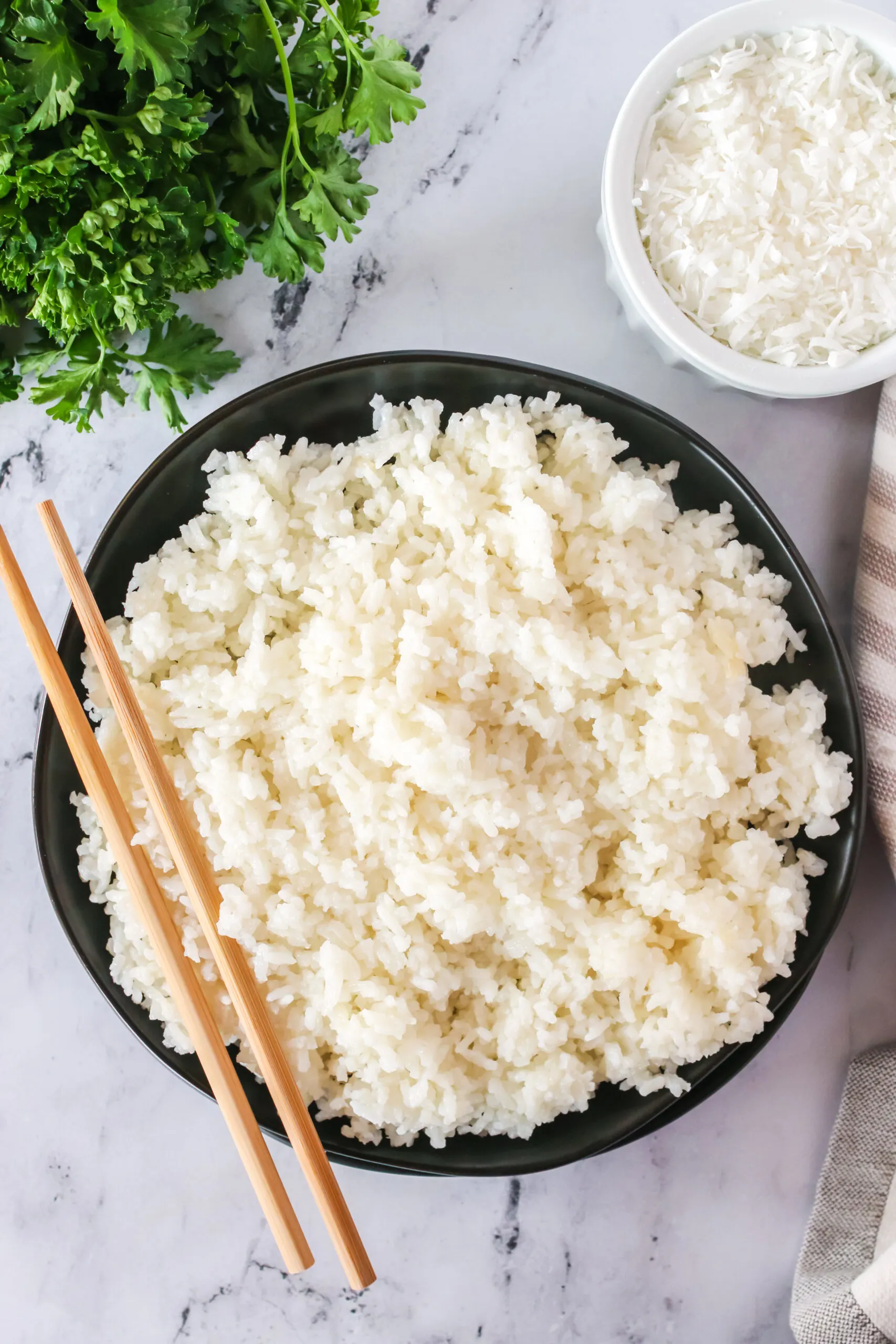 top view looking down of coconut jasmine rice in a serving bowl with chop sticks