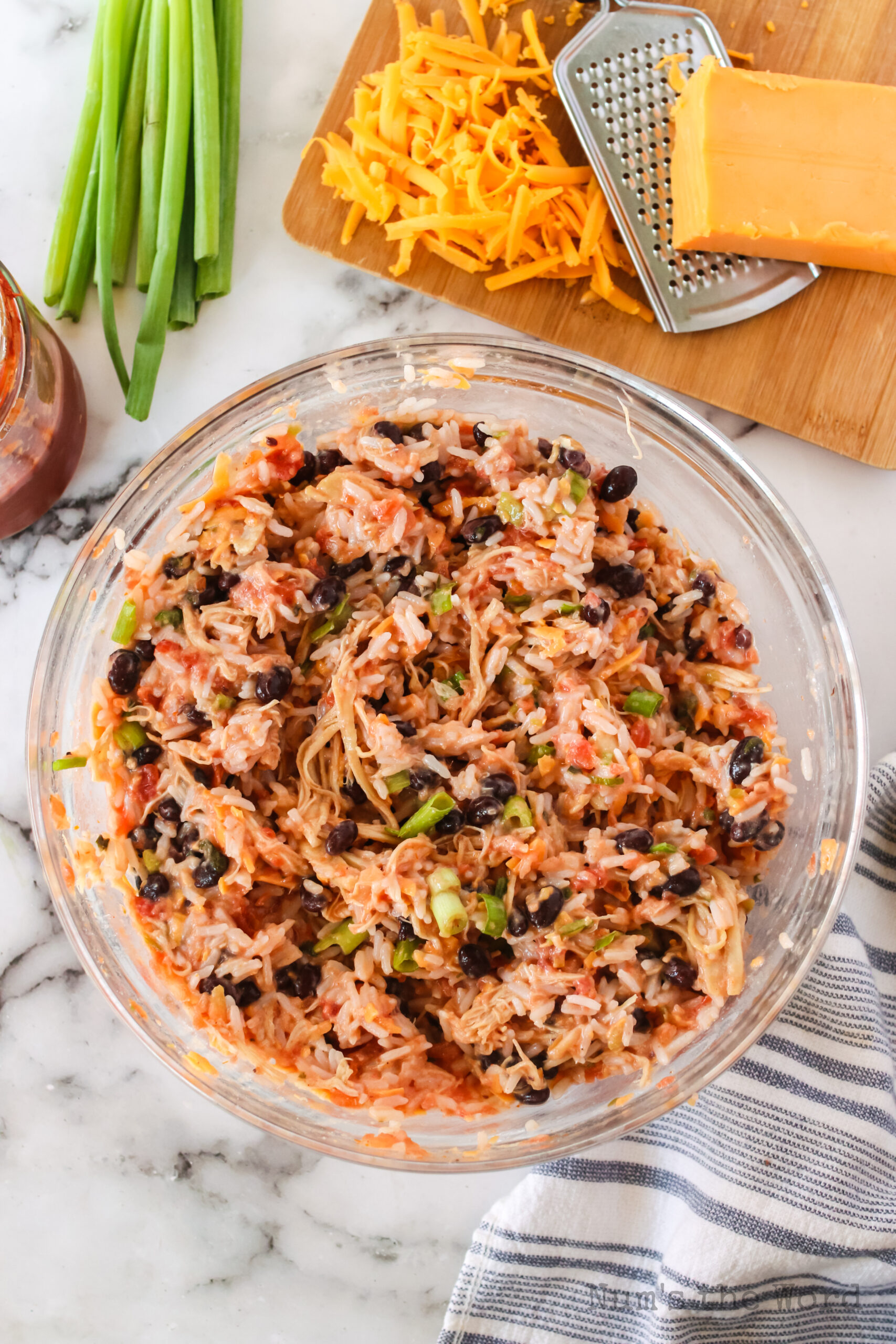 sour cream, salsa, black beans, cheddar cheese, green onions and rice mixed in a bowl