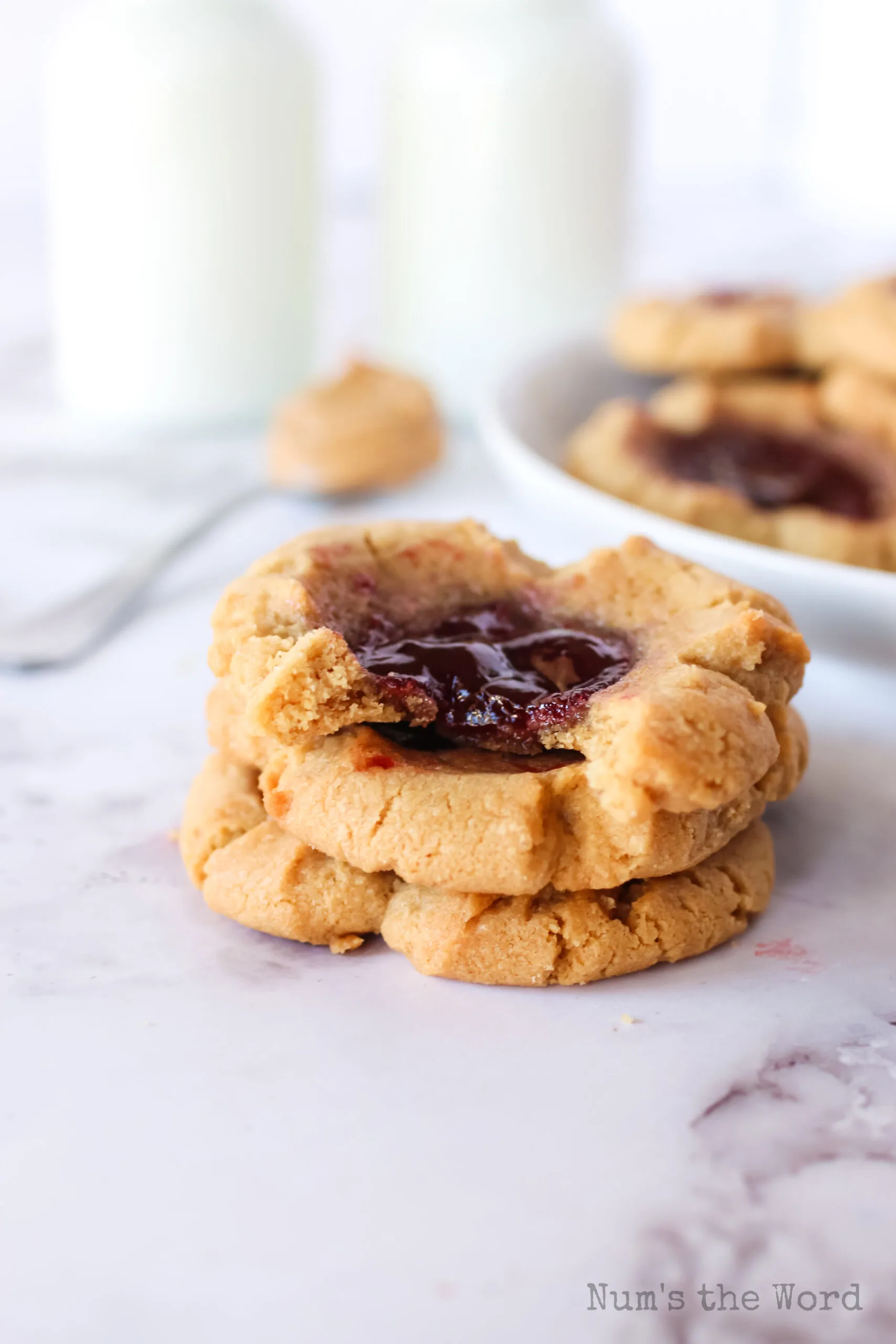 two Jelly thumb print cookies stacked on top of each other