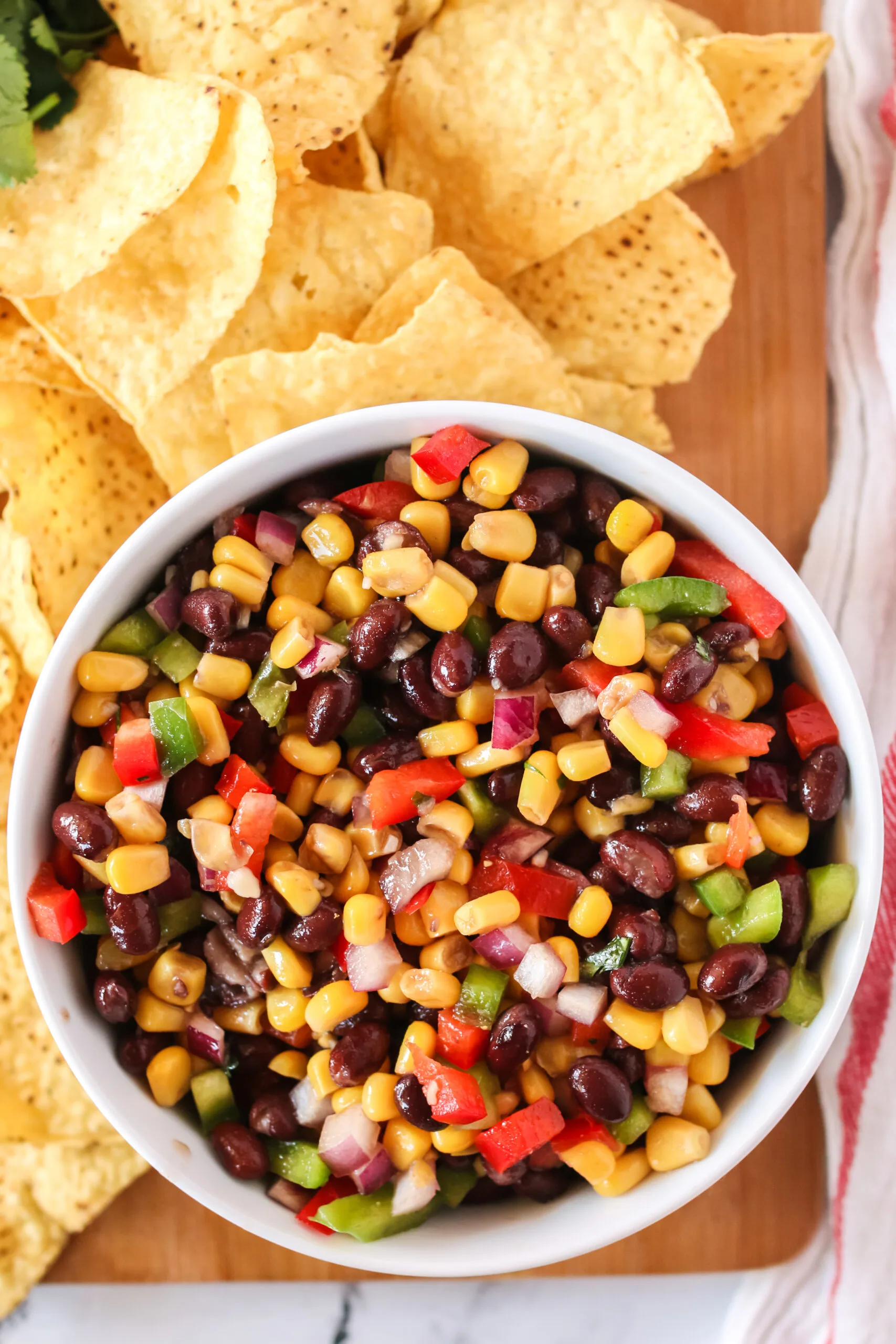 top view of black bean salsa in a bowl with chips all around.