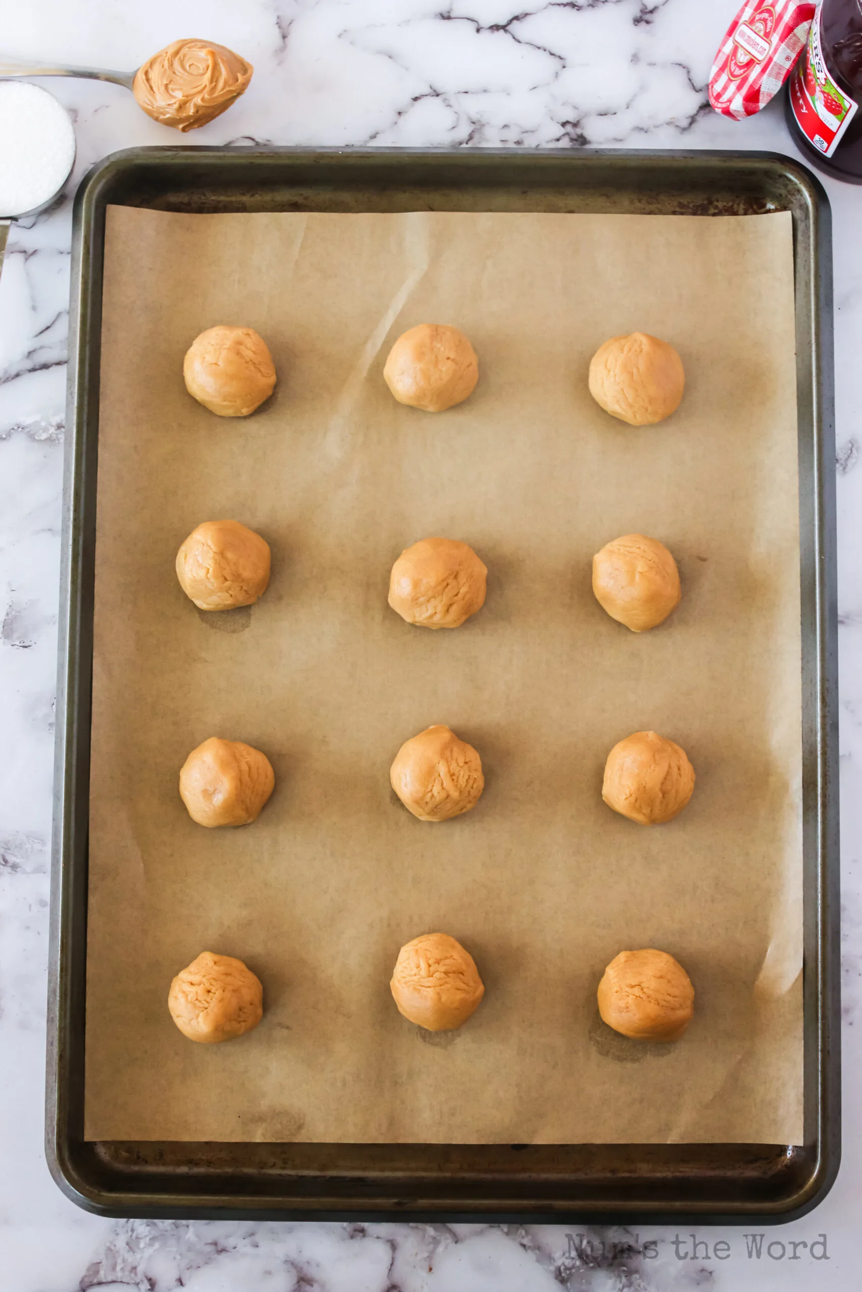 12 dough balls on a baking sheet