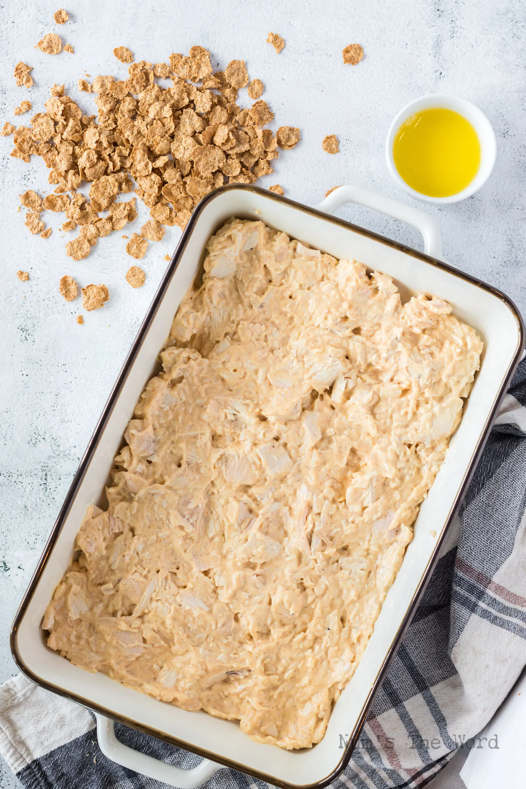 Mixed casserole ingredients added to casserole dish, cornflakes are not placed on top