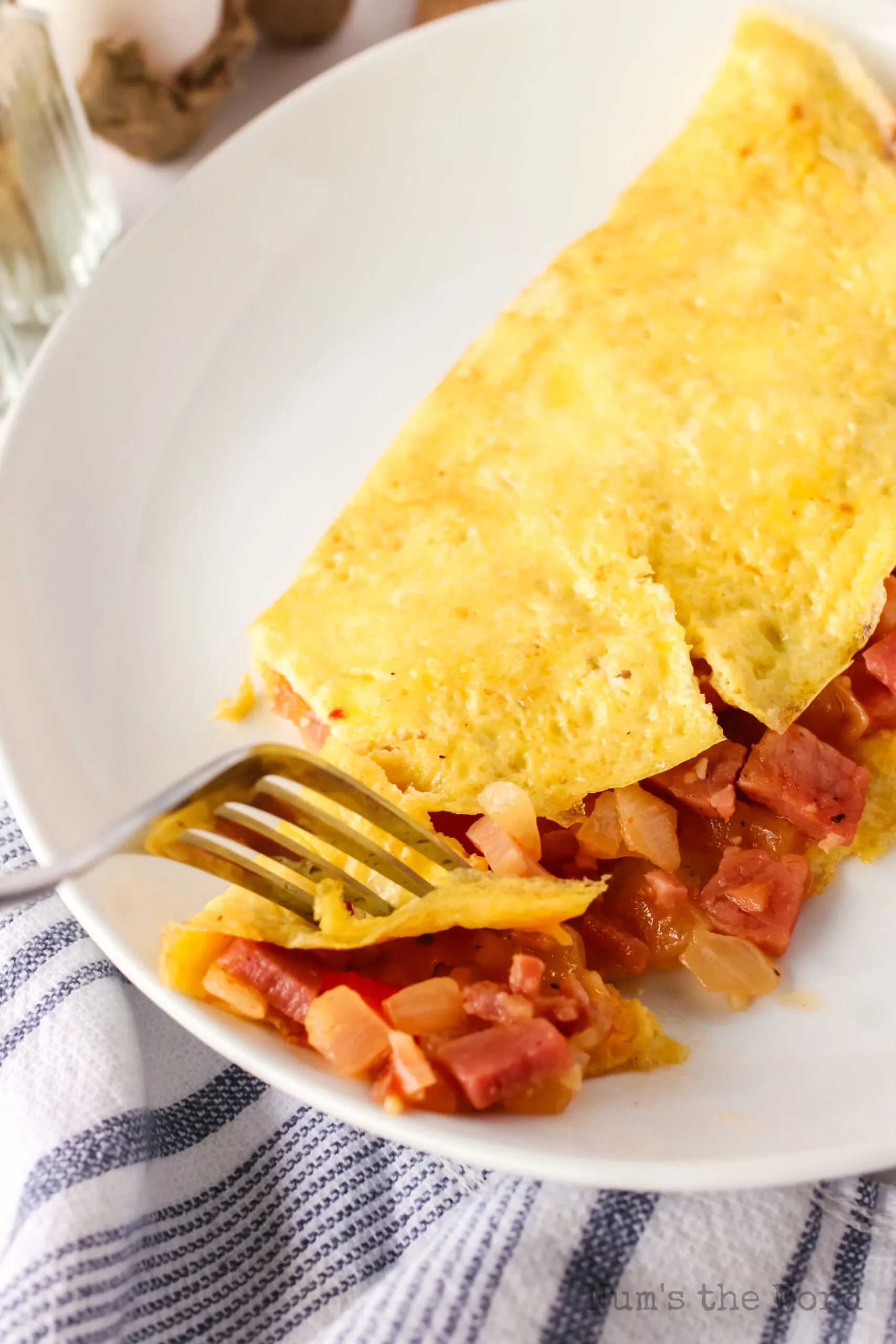 fork cutting a piece of omelette to eat