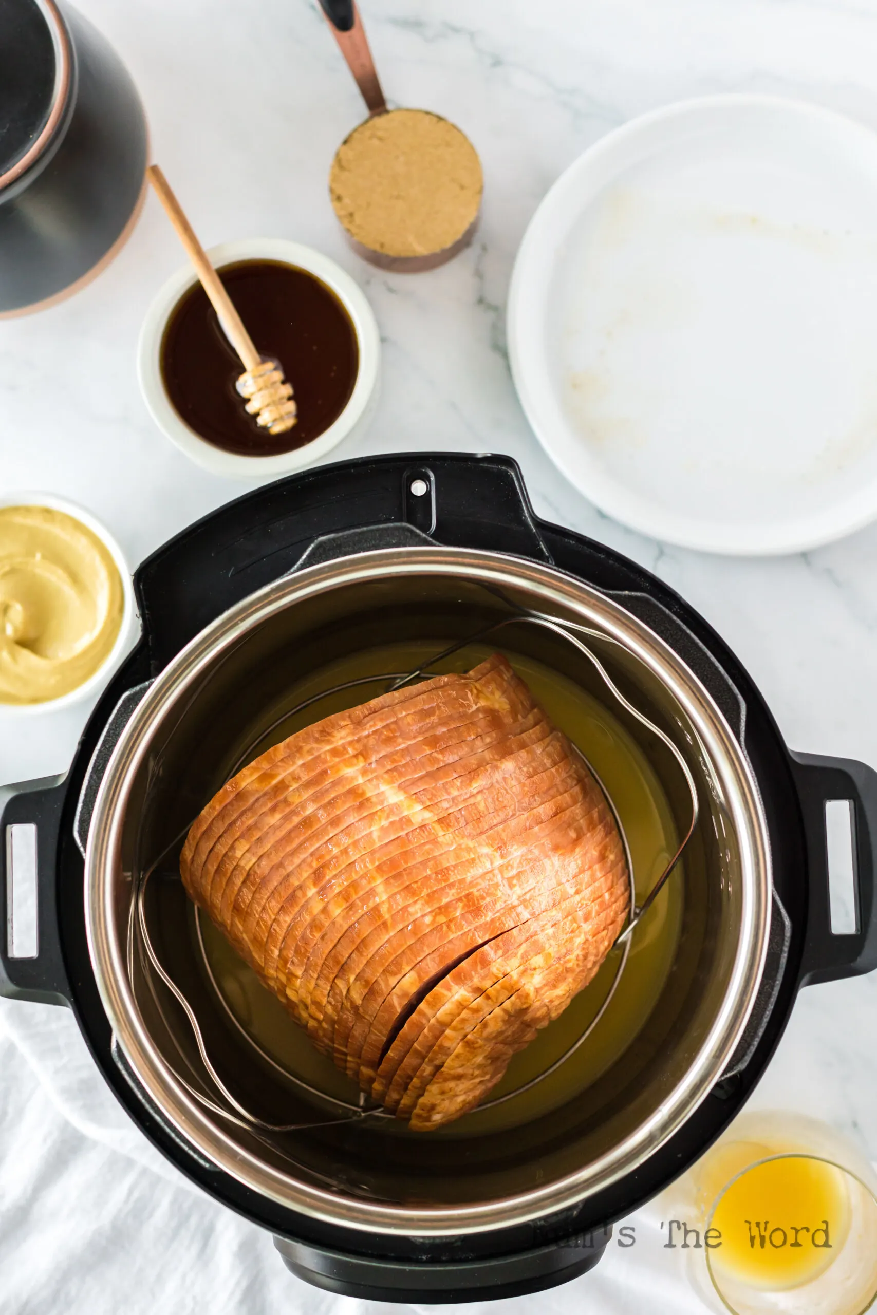 Ham placed on a trivet in the instant pot above the pineapple juice