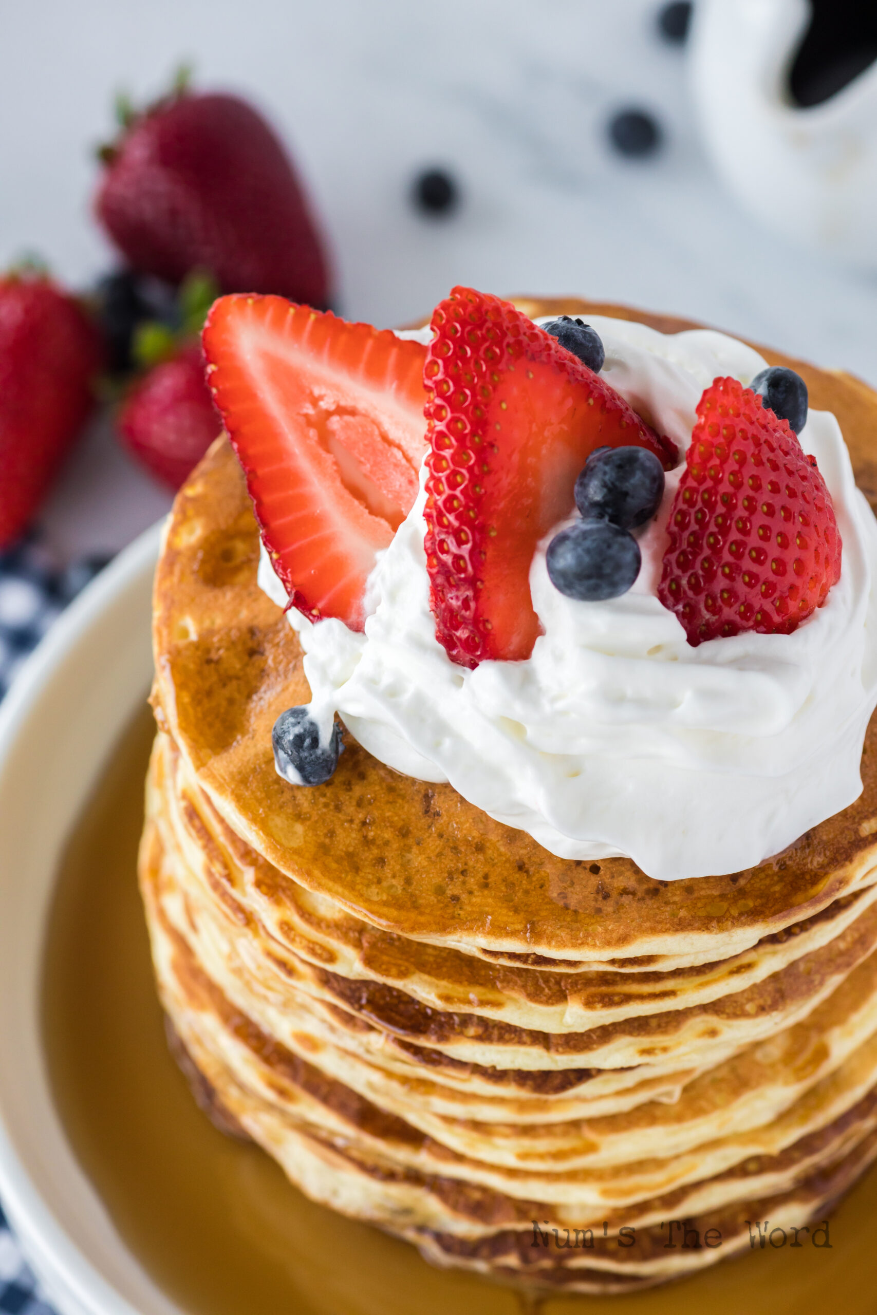 pancakes with syrup, whipped cream and fruit on top