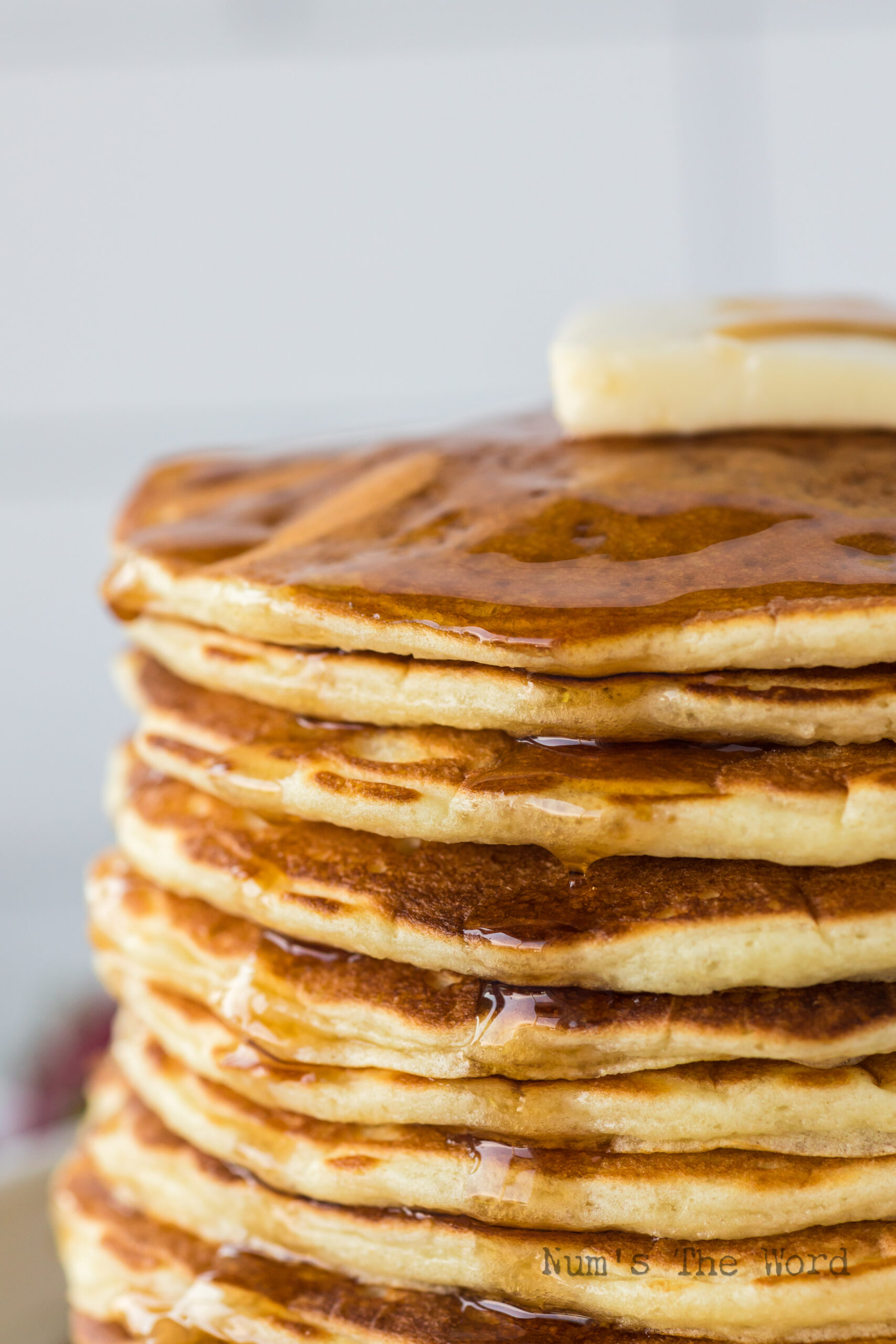 close up of pancakes with butter and syrup.