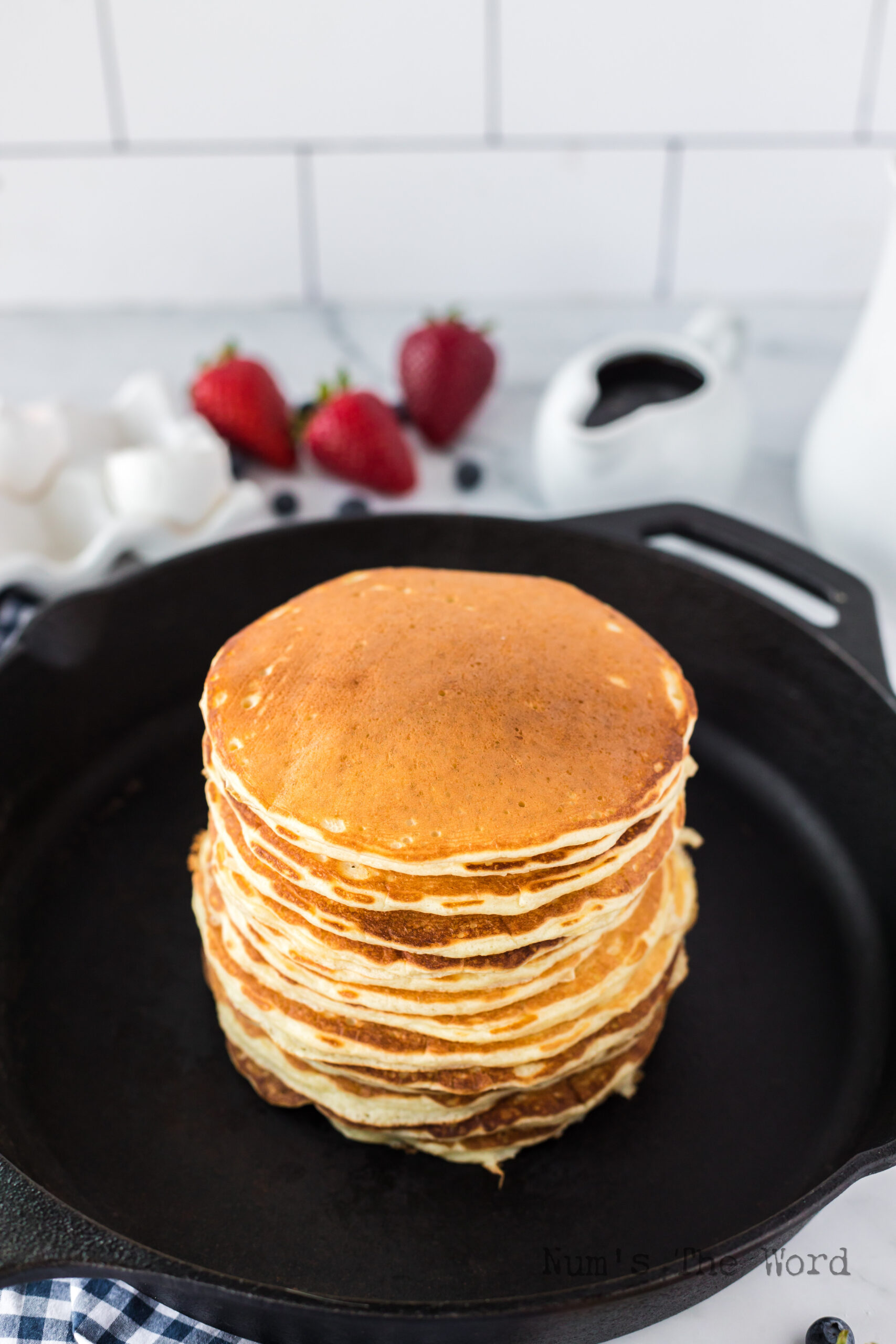 a stack of buttermilk pancakes in cast iron skillet