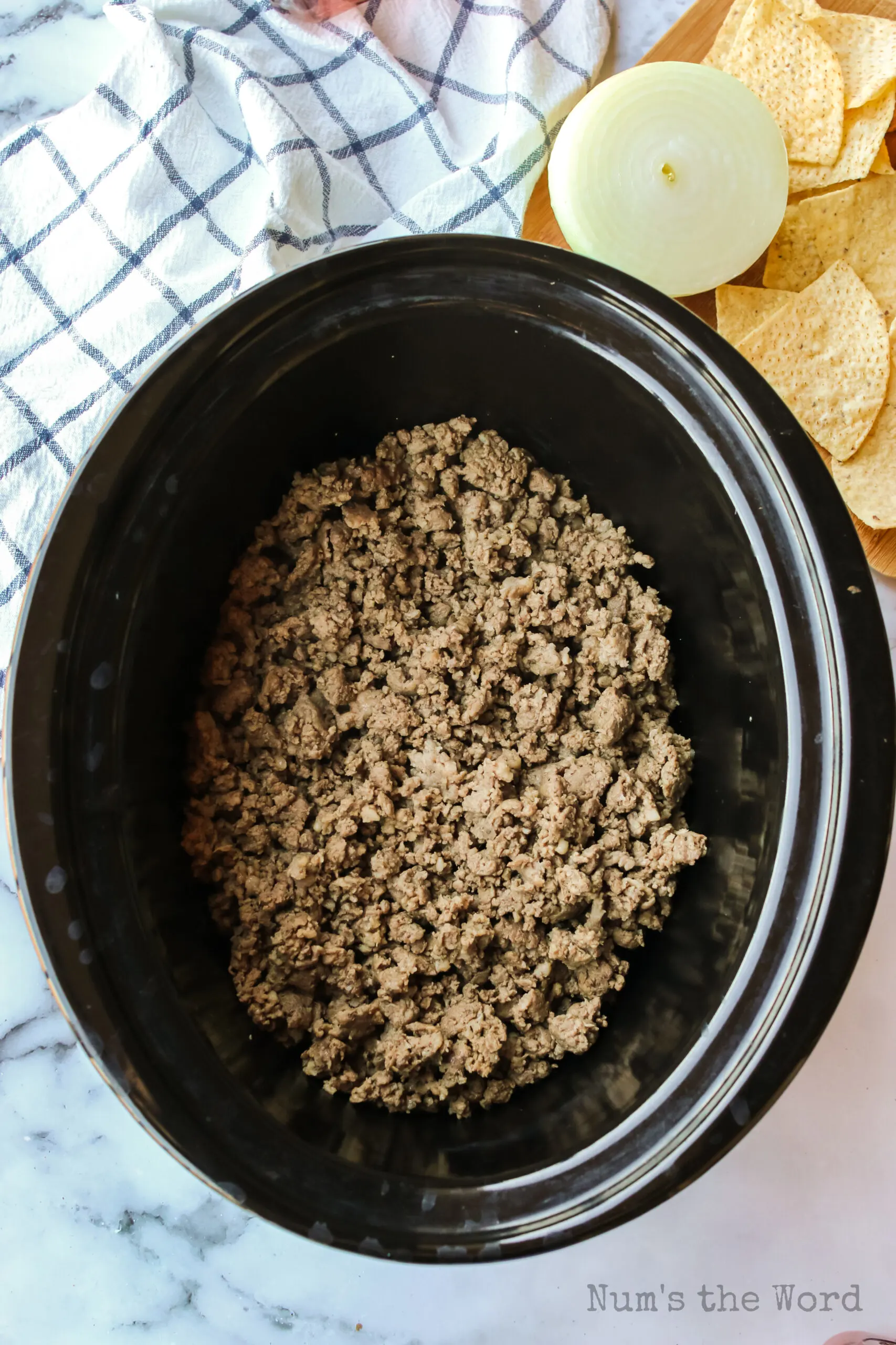 cooked ground beef and sausage placed in a crock pot