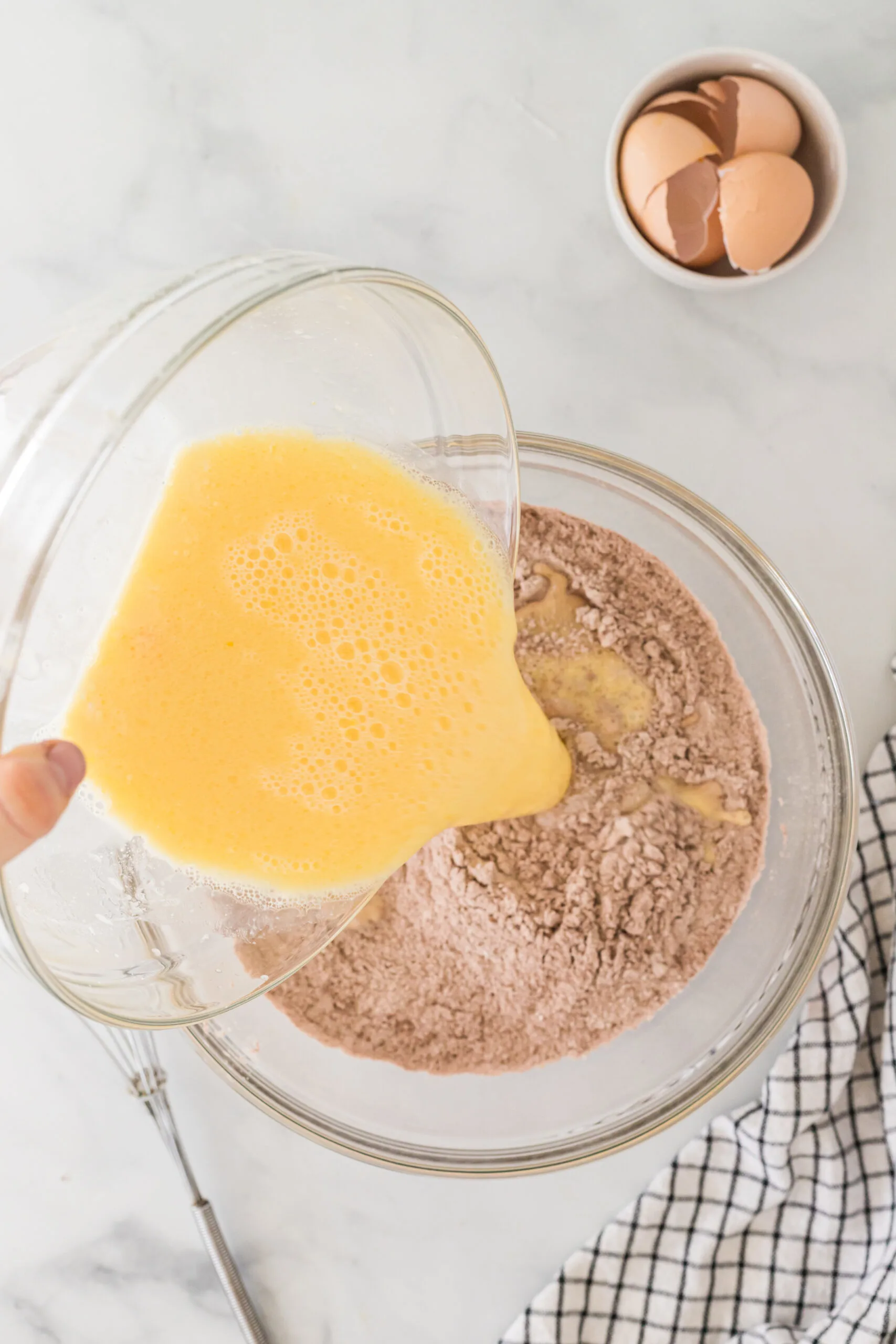 egg mixture being poured into dry mixture.