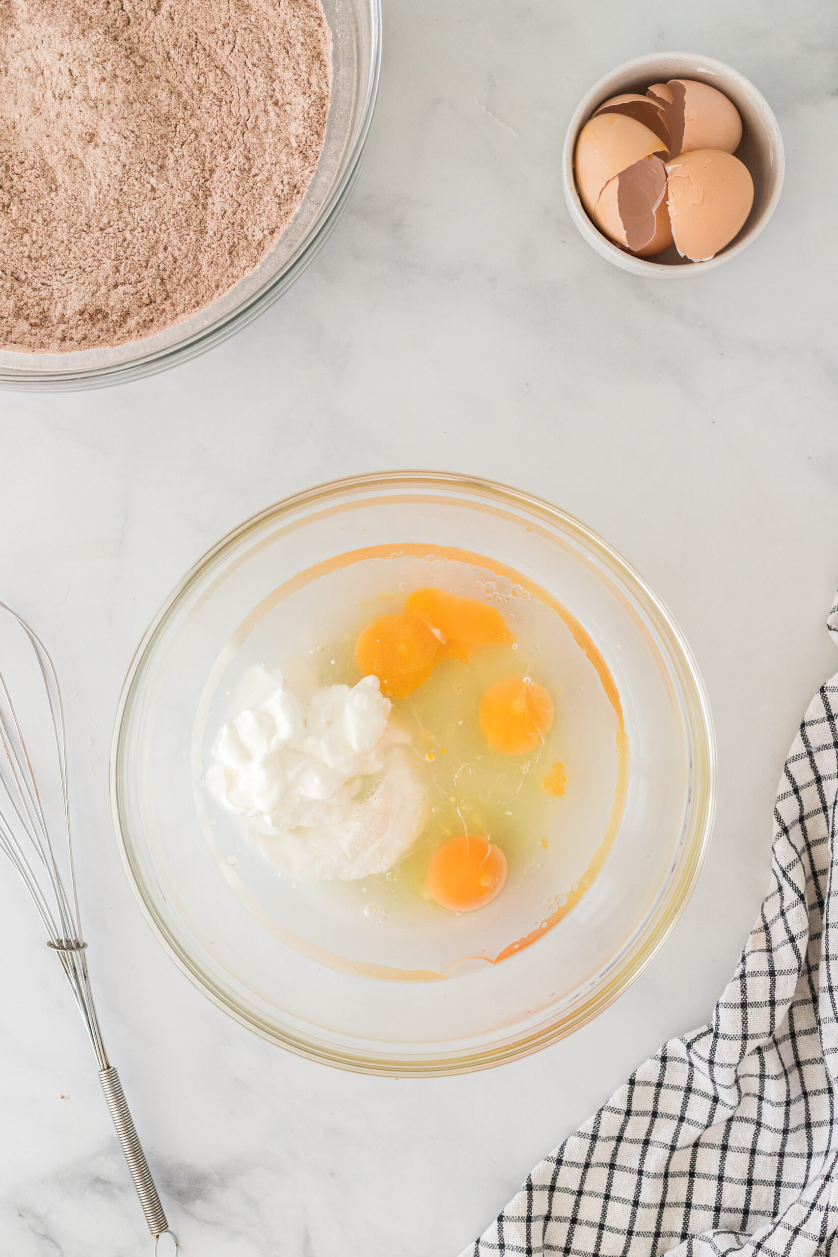eggs, water, yogurt, and vegetable oil in a bowl unmixed.
