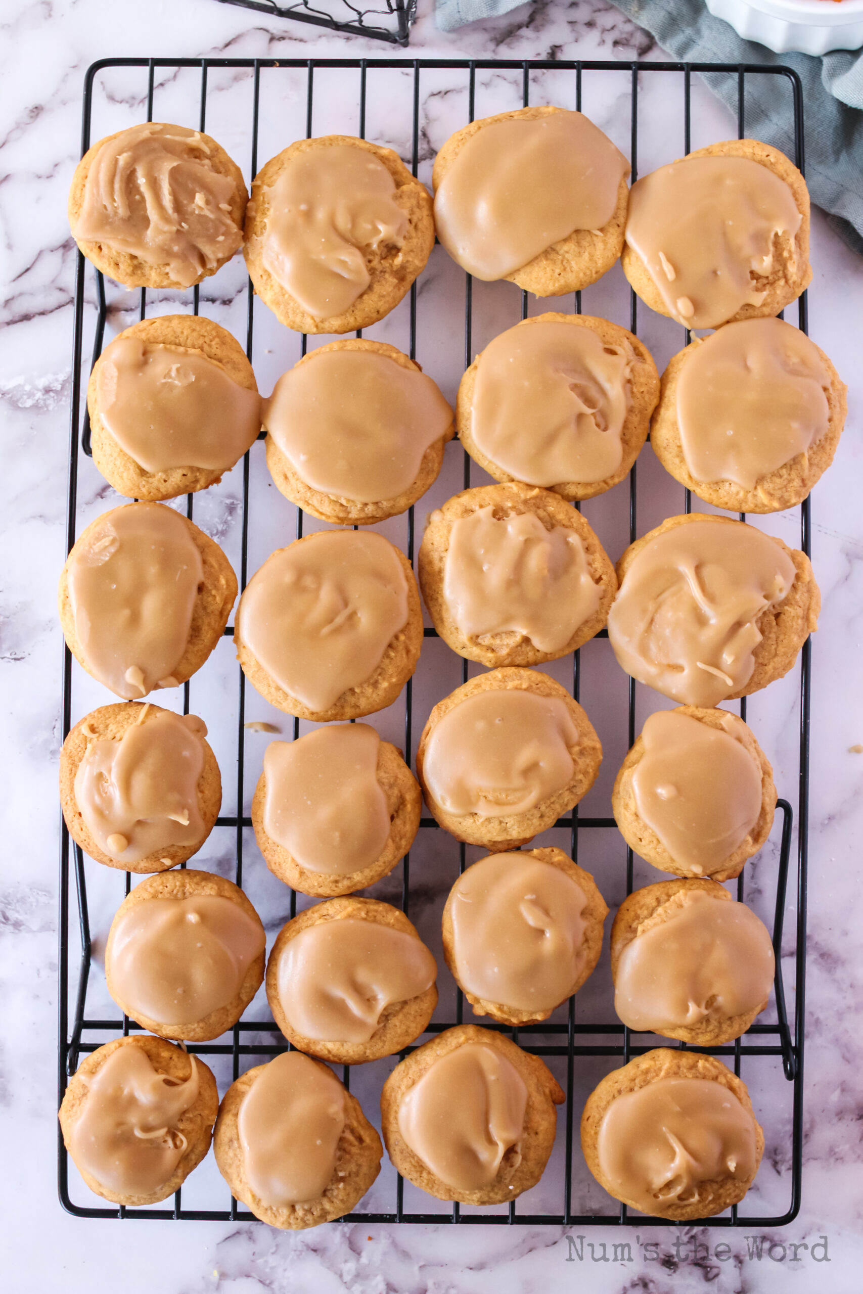 Pumpkin Cookies on a cooling rack covered in brown butter frosting