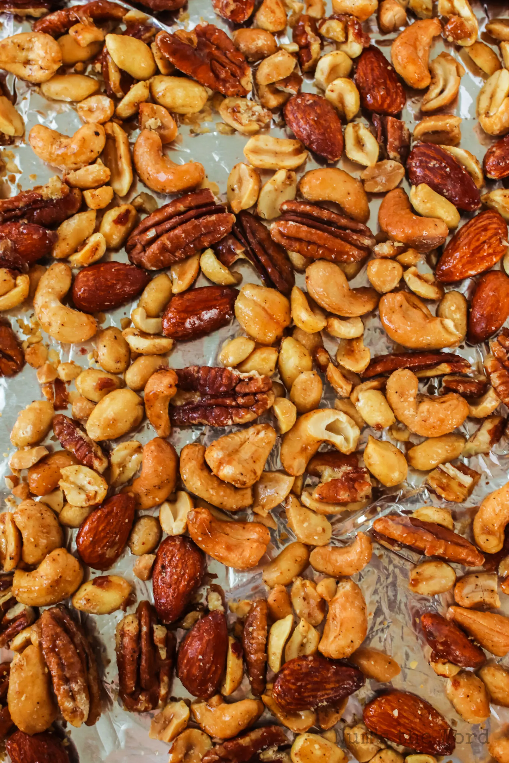 zoomed in image of cooked mixed nuts on cookie sheet