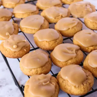 penuche frosted pumpkin cookies on a cooling rack