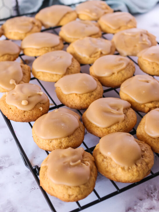 penuche frosted pumpkin cookies on a cooling rack