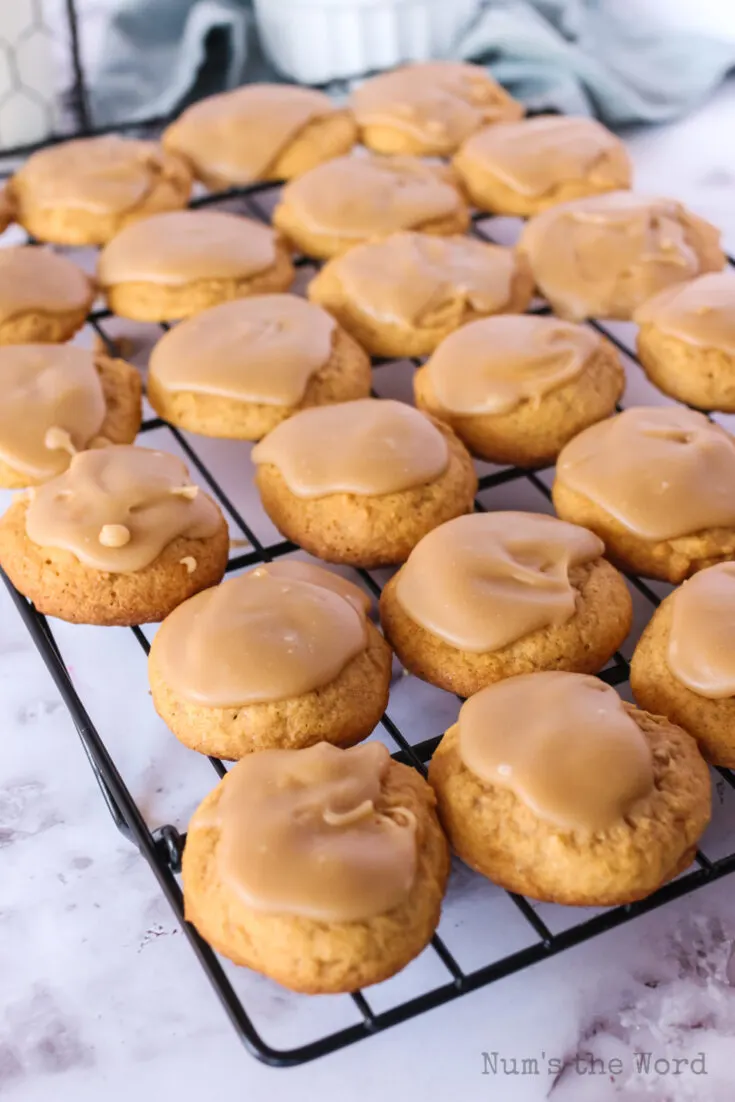 penuche frosted pumpkin cookies on a cooling rack