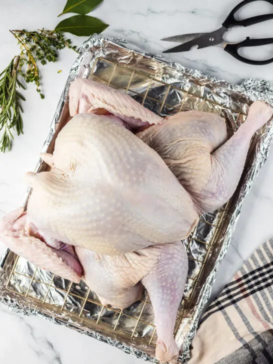 turkey on cooling rack above cookie sheet, ready to be put into the oven