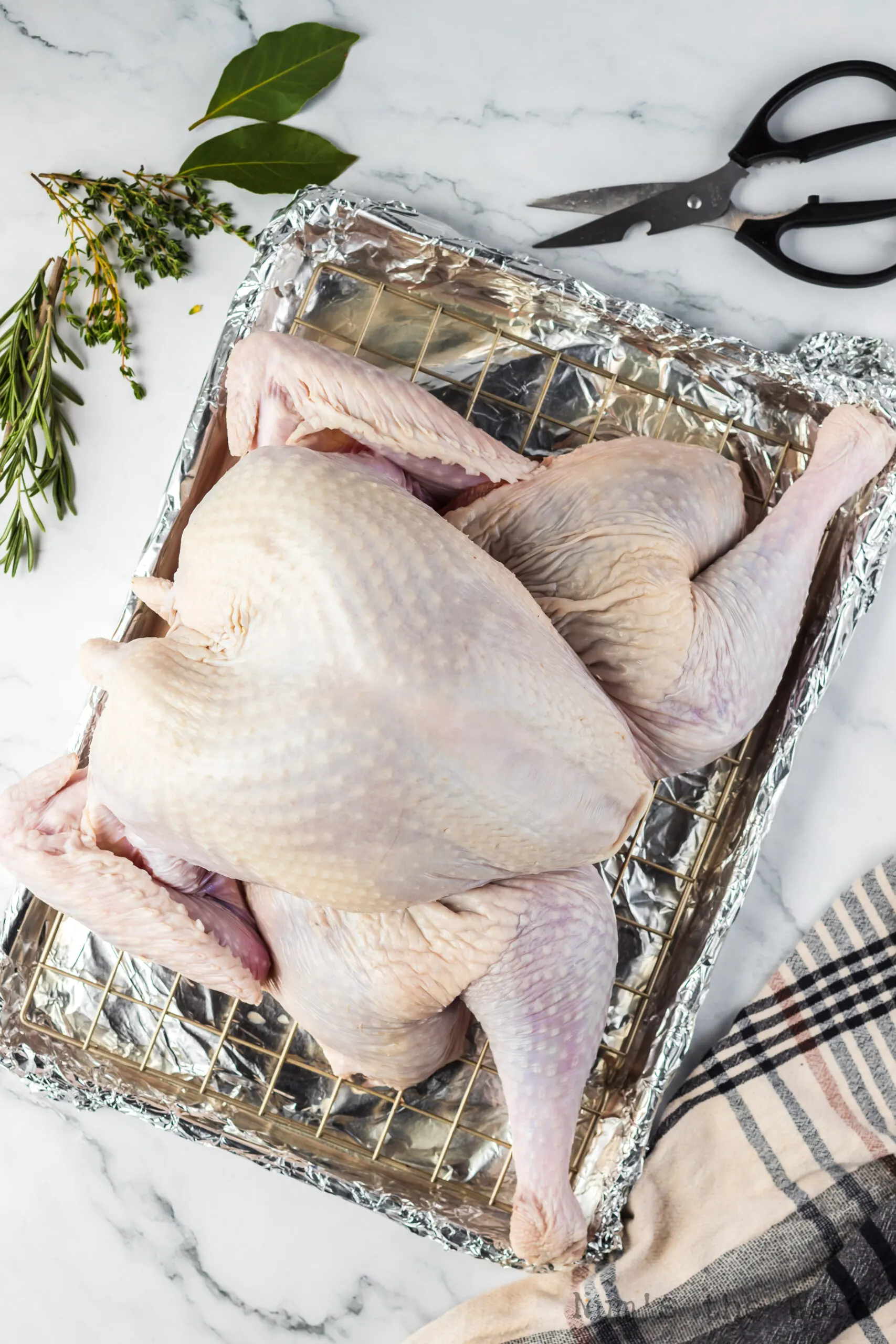 turkey on cooling rack above cookie sheet, ready to be put into the oven