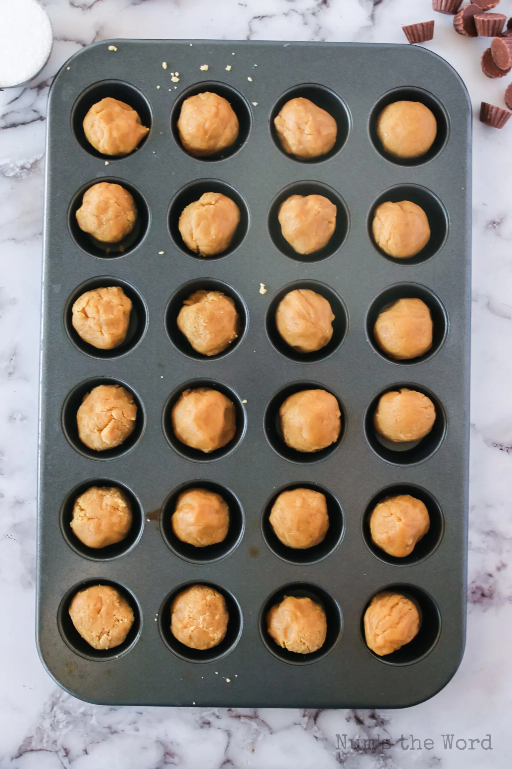 peanut butter cookie dough balls in a mini muffin tin