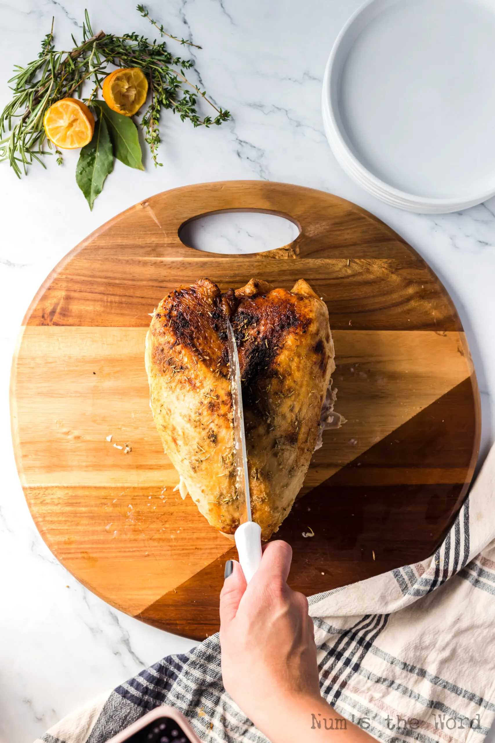 knife positioned above the turkey breast to show how to cut the breast off the bone