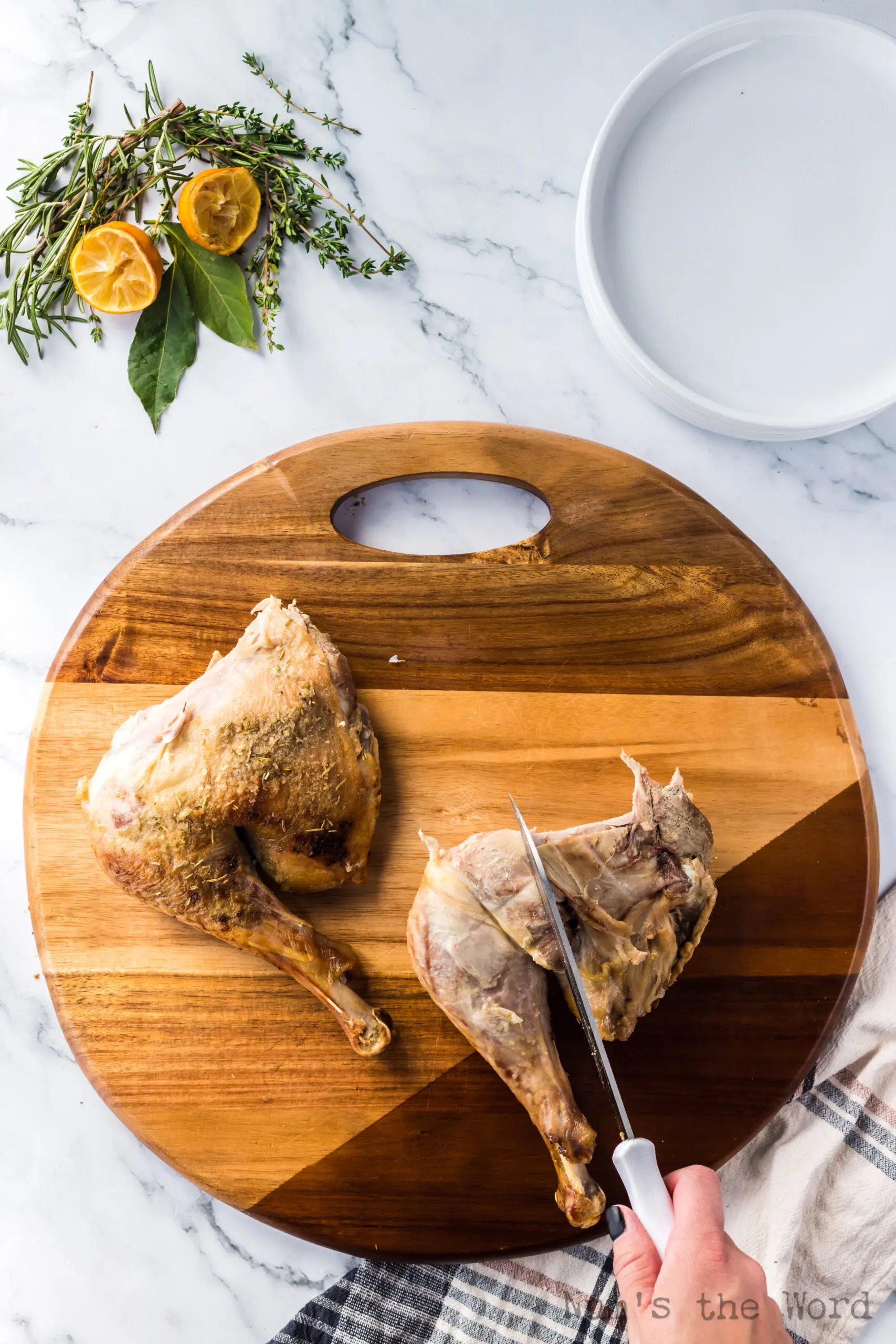 turkey thigh laid out with knife showing where to cut to create a thigh piece and a leg piece