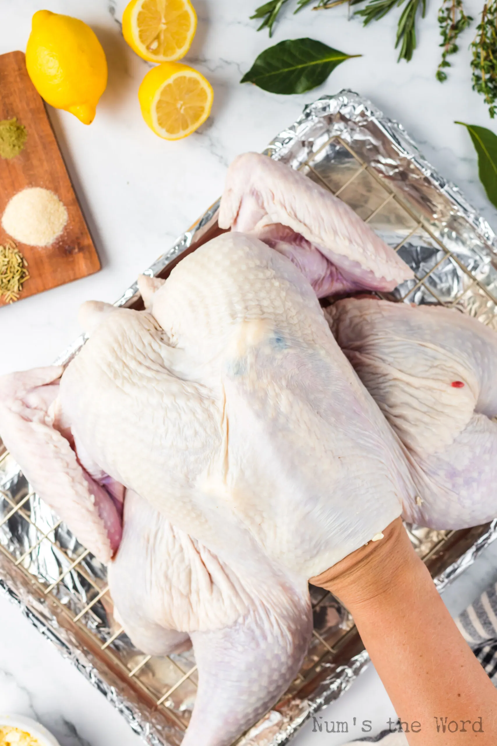 butter being rubbed under the skin of the turkey