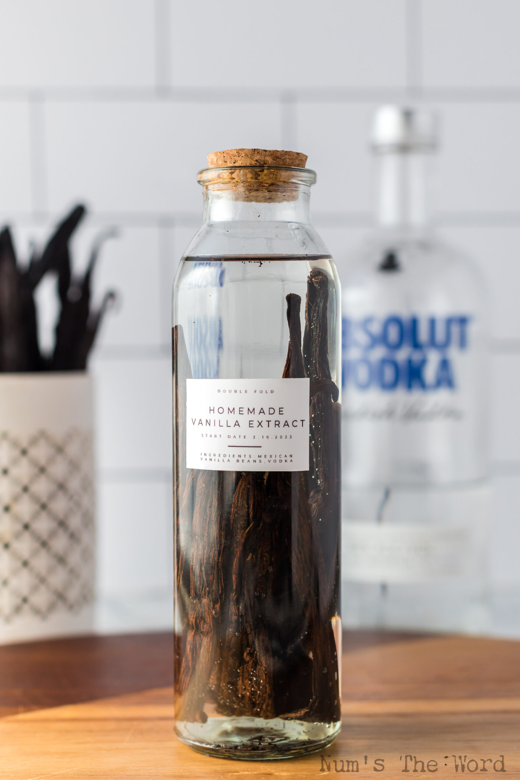 zoomed out image of a bottle of freshly made vanilla extract on counter.