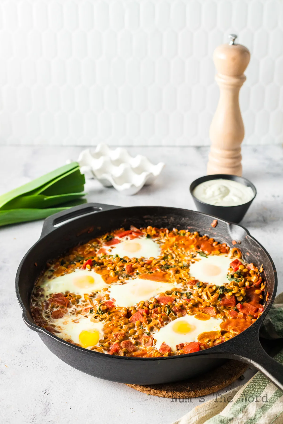side view of eggs and lentils in skillet ready to serve