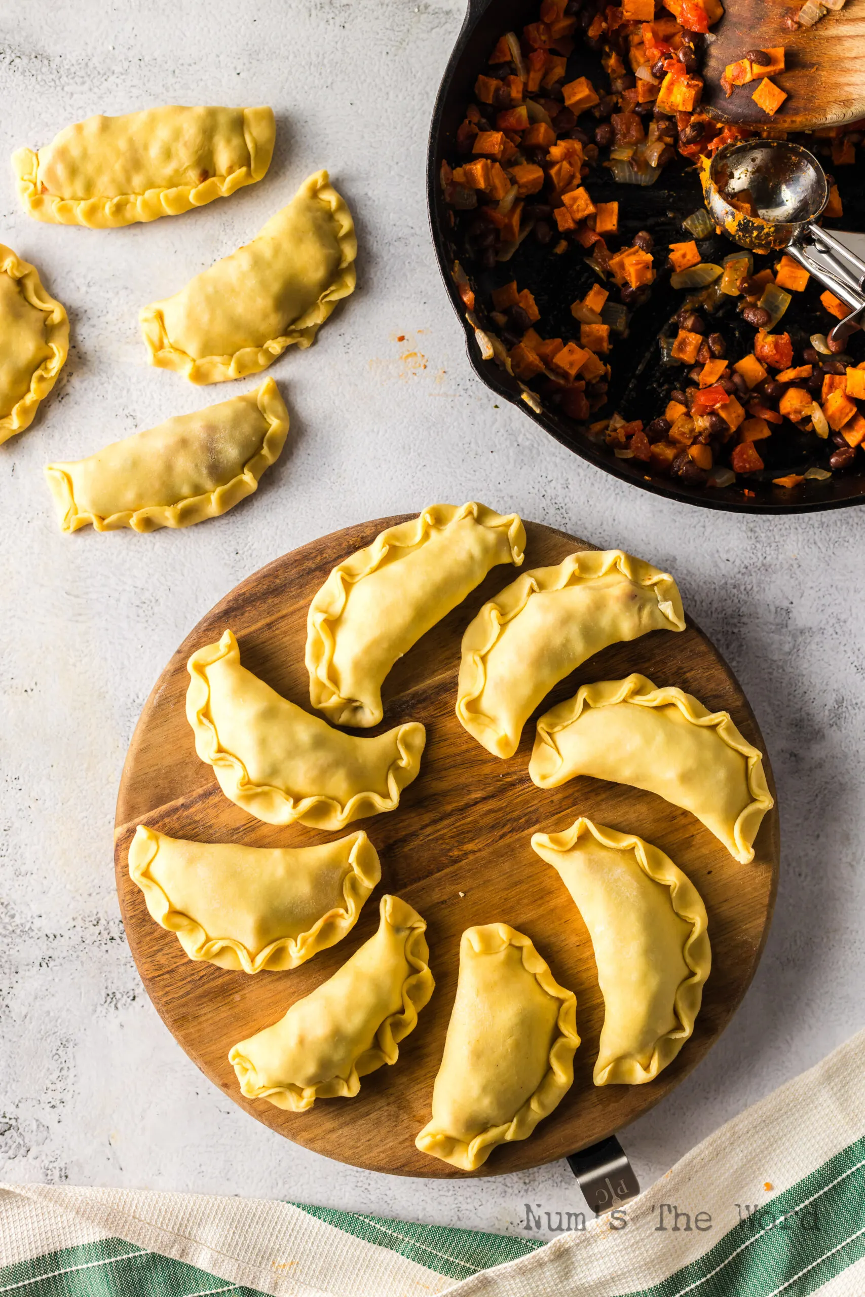 uncooked empanadas rolled, filled and folded and ready to be baked