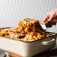 Spatula scooping a portion of pasta casserole out of dish